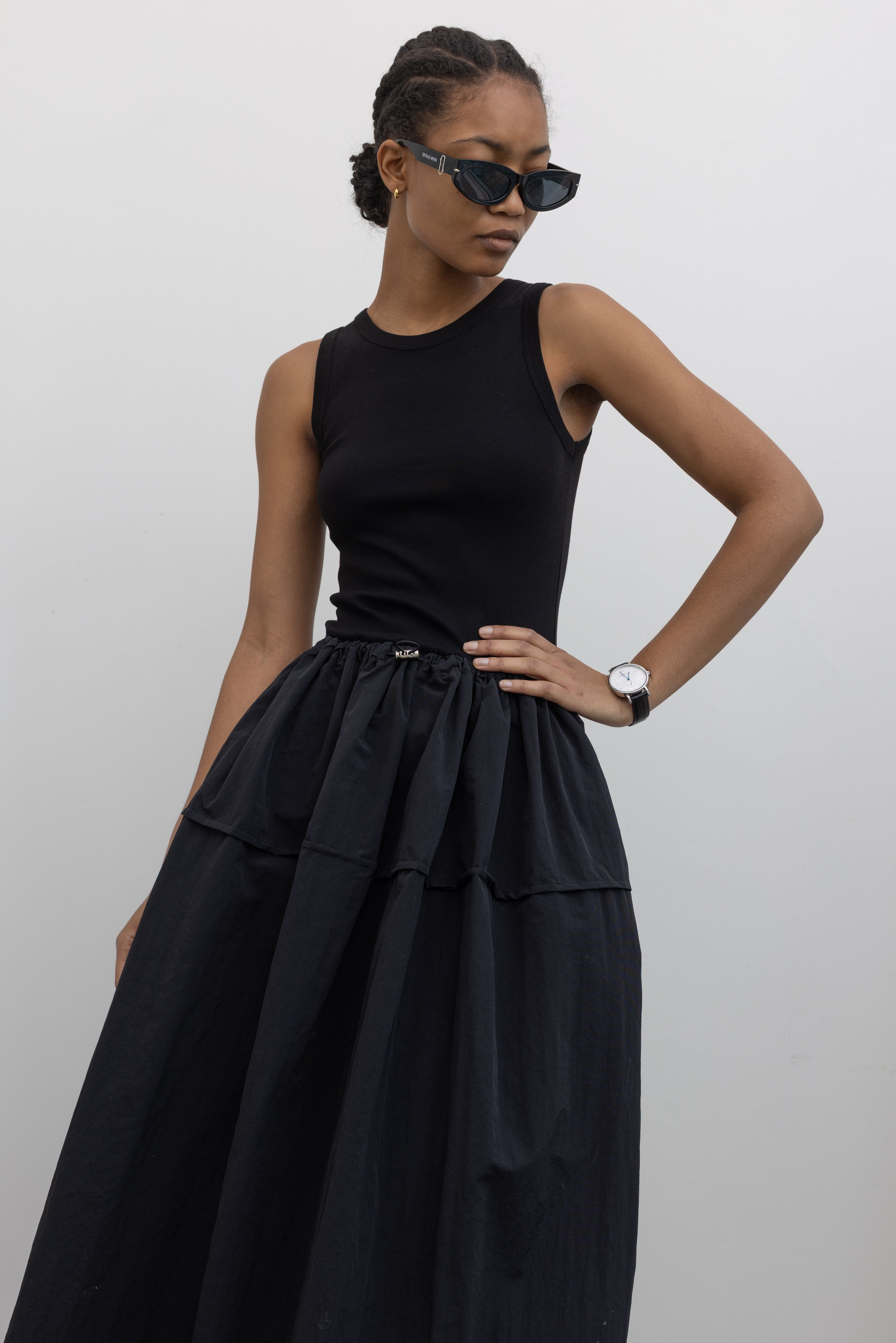 Woman wearing Spring fashion in a flattering Alas Eius brand dress with a  cotton bodice and a structured nylon skirt cinched by an adjustable drawstring waist paired with sunglasses at Alas Eius 