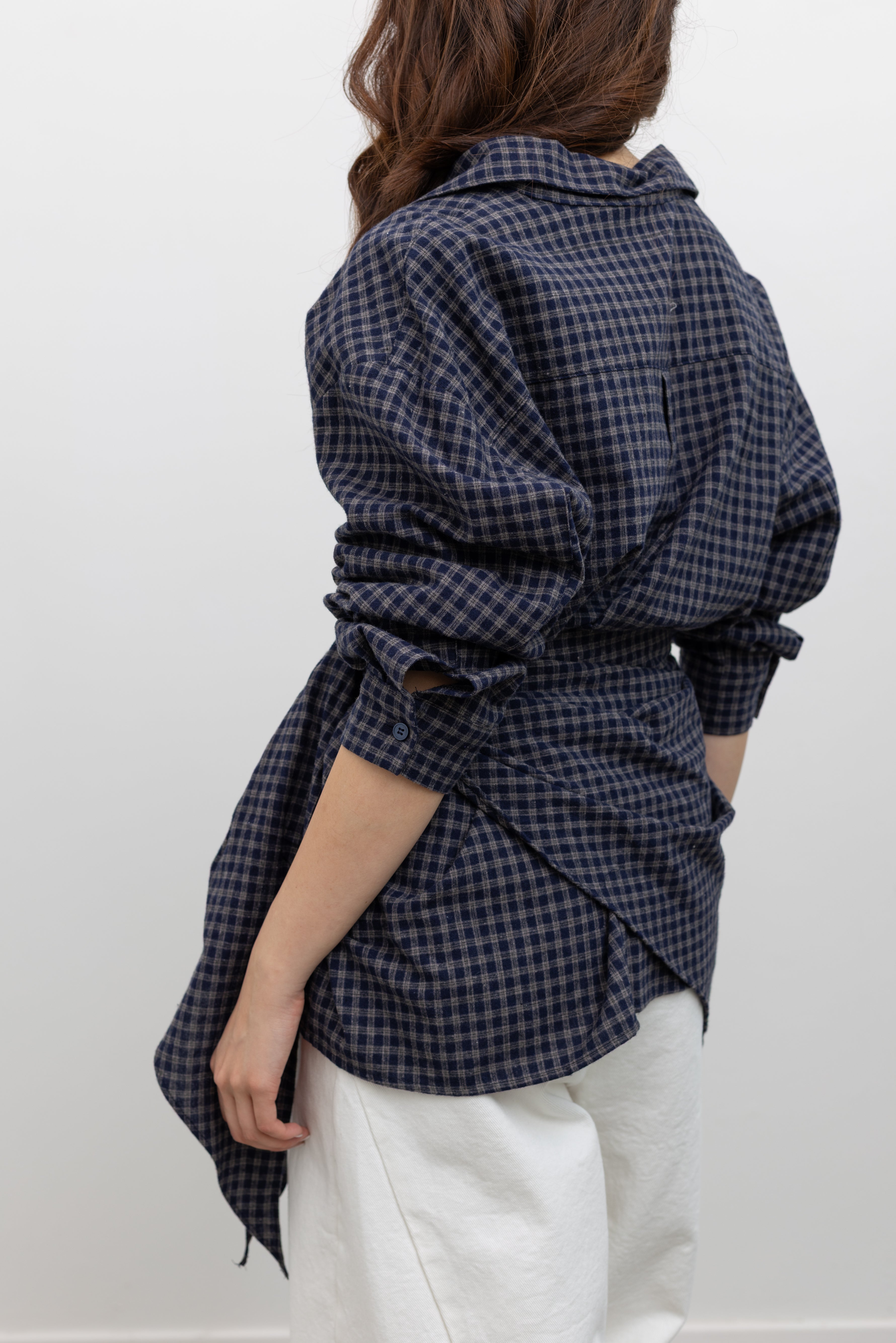 Alas Eius label oversized navy blue and tan plaid button-down top styled with coordinating bandana scarf around waist for a flattering cinched look paired with white denim jeans at Alas Eius. 