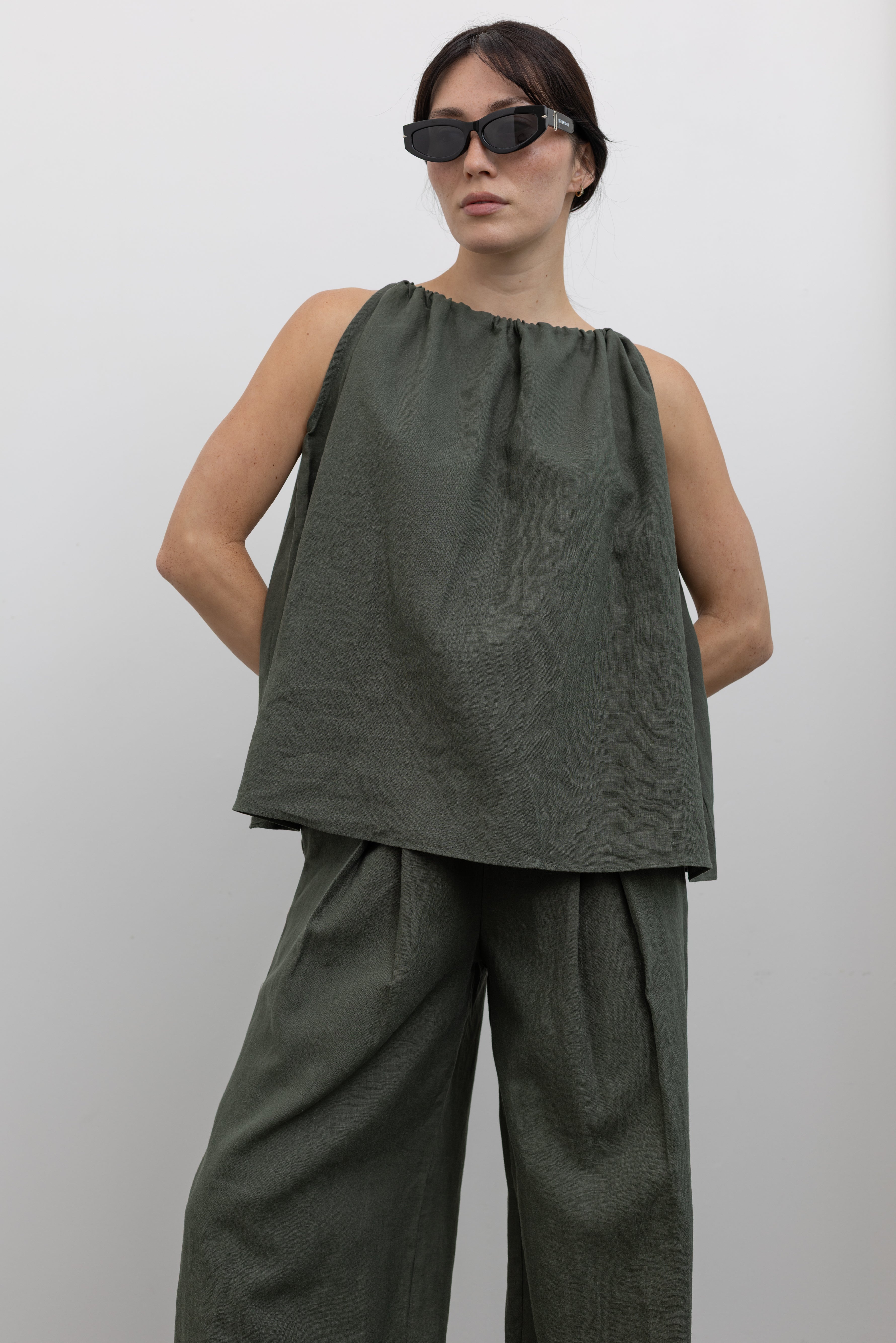Woman standing wearing spring fashion in an Alas Eius Label Cotton and Linen Blend Halter Neck Voluminous Top at Alas Eius.