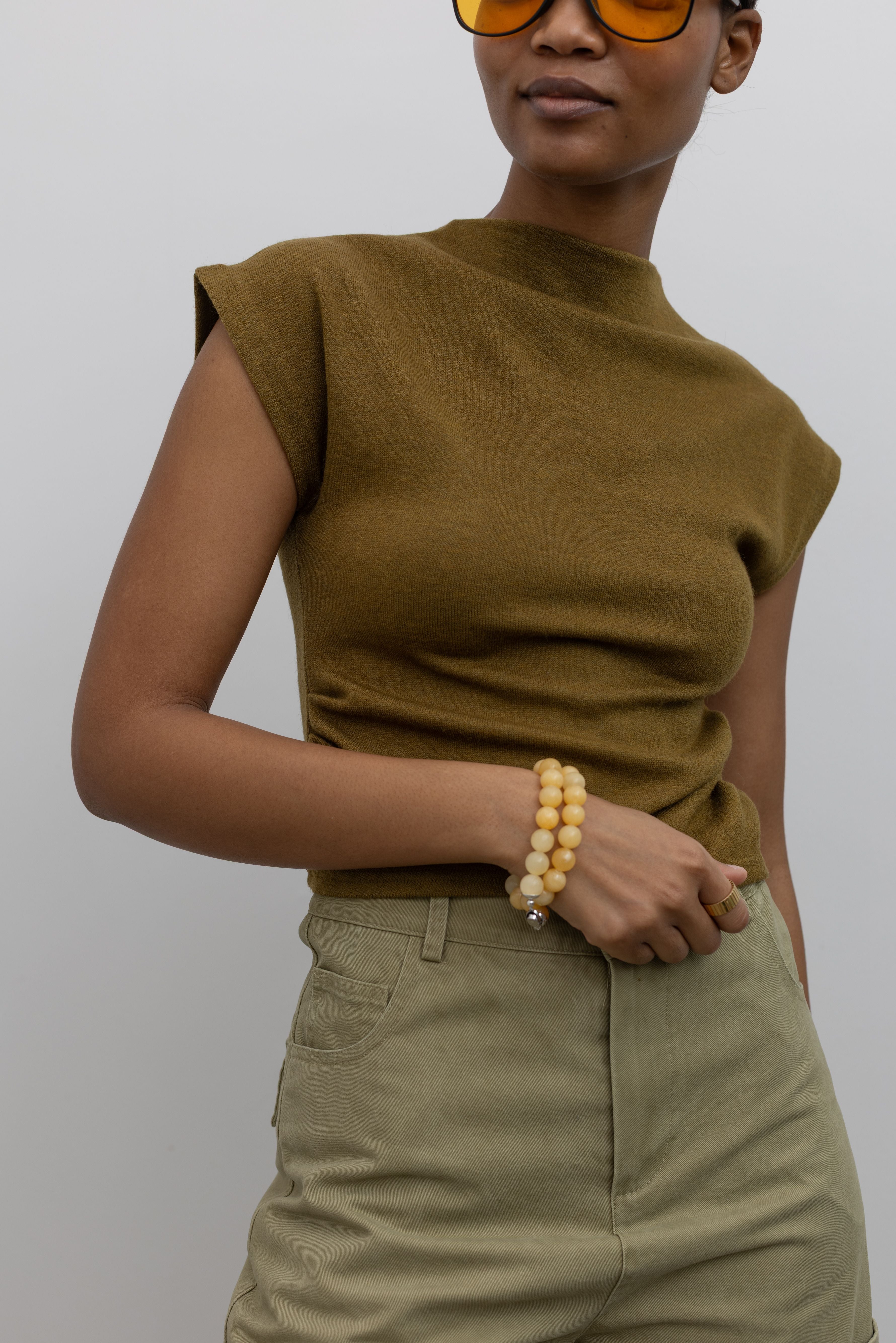 Close-up front view of a woman wearing modest and chic Alas Eius label olive mock neck knit fitted top at Alas Eius
