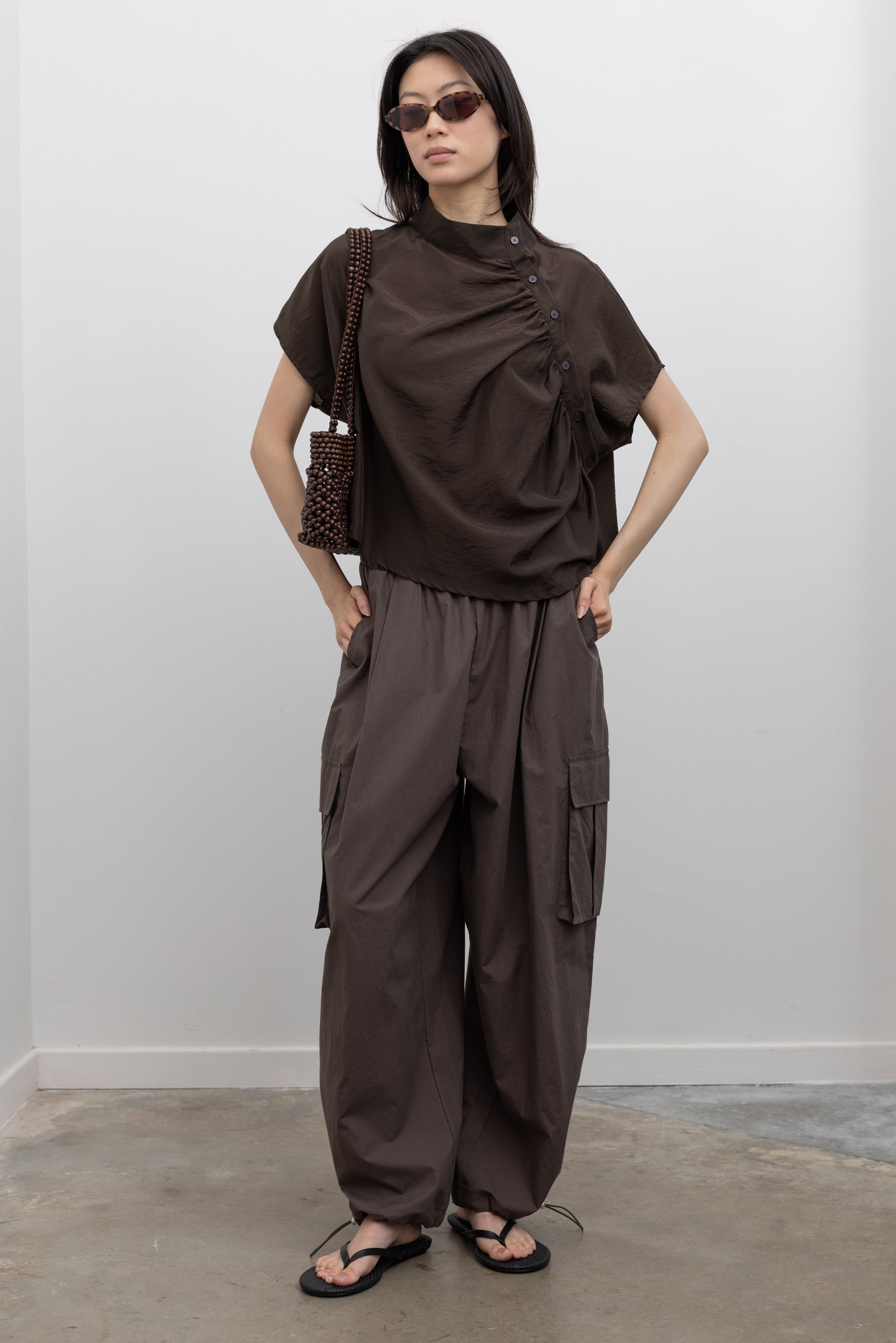Alas Eius lightweight cotton wide leg cargo pants featuring an oversized silhouette, adjustable ankle bungee cords, and drawstring waist, styled as a modern women’s utility fashion essential at Alas Eius