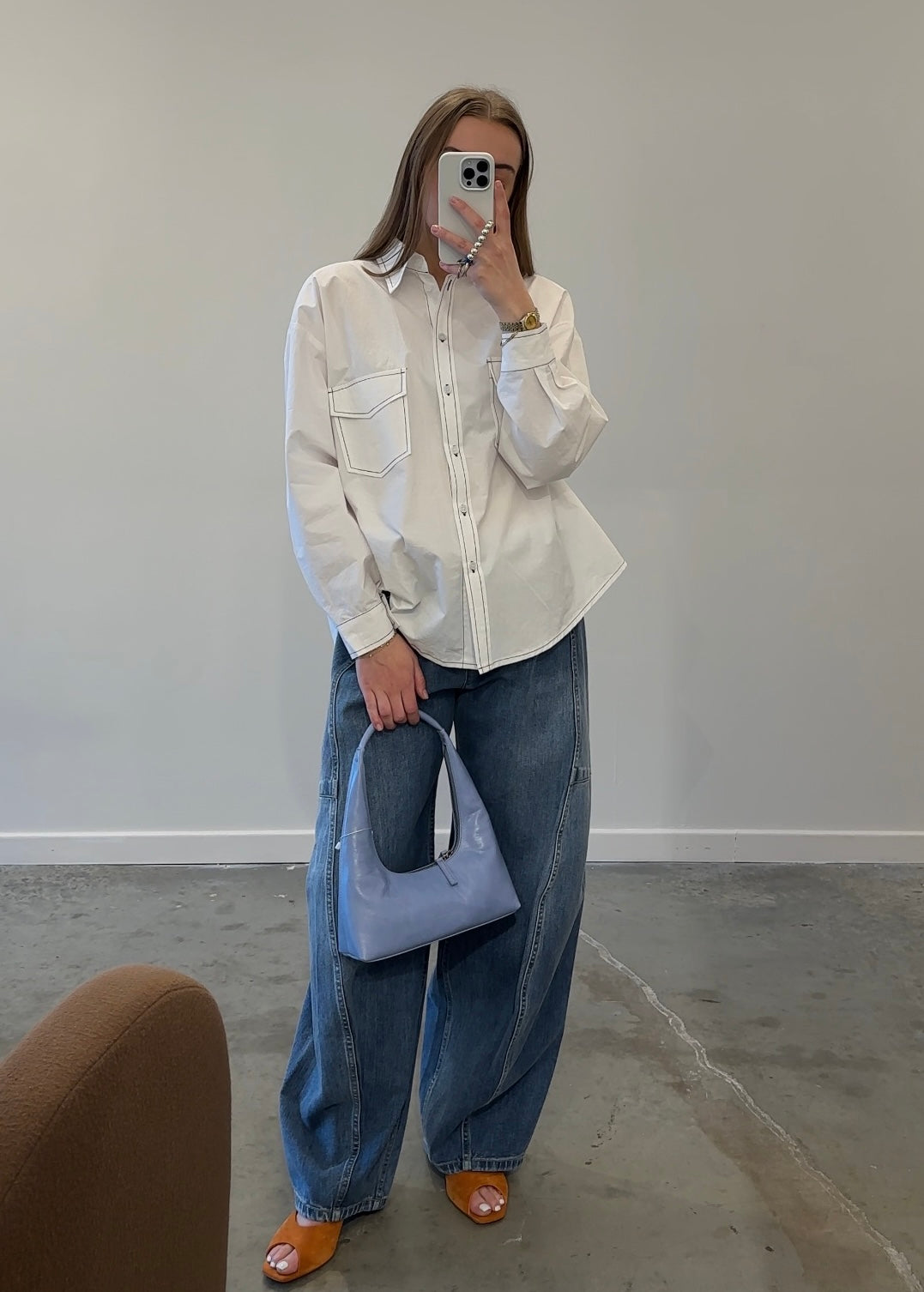 Mirror selfie of white contrast stitch oversized button down shirt with jeans 