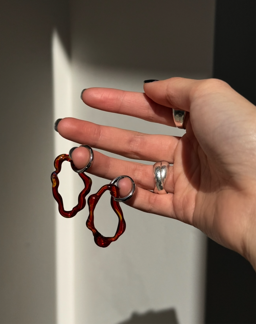 Alma hoop earrings designed in an organic shaped hoop, made out of and beautiful honey tone glass at an Alas Eius store. 