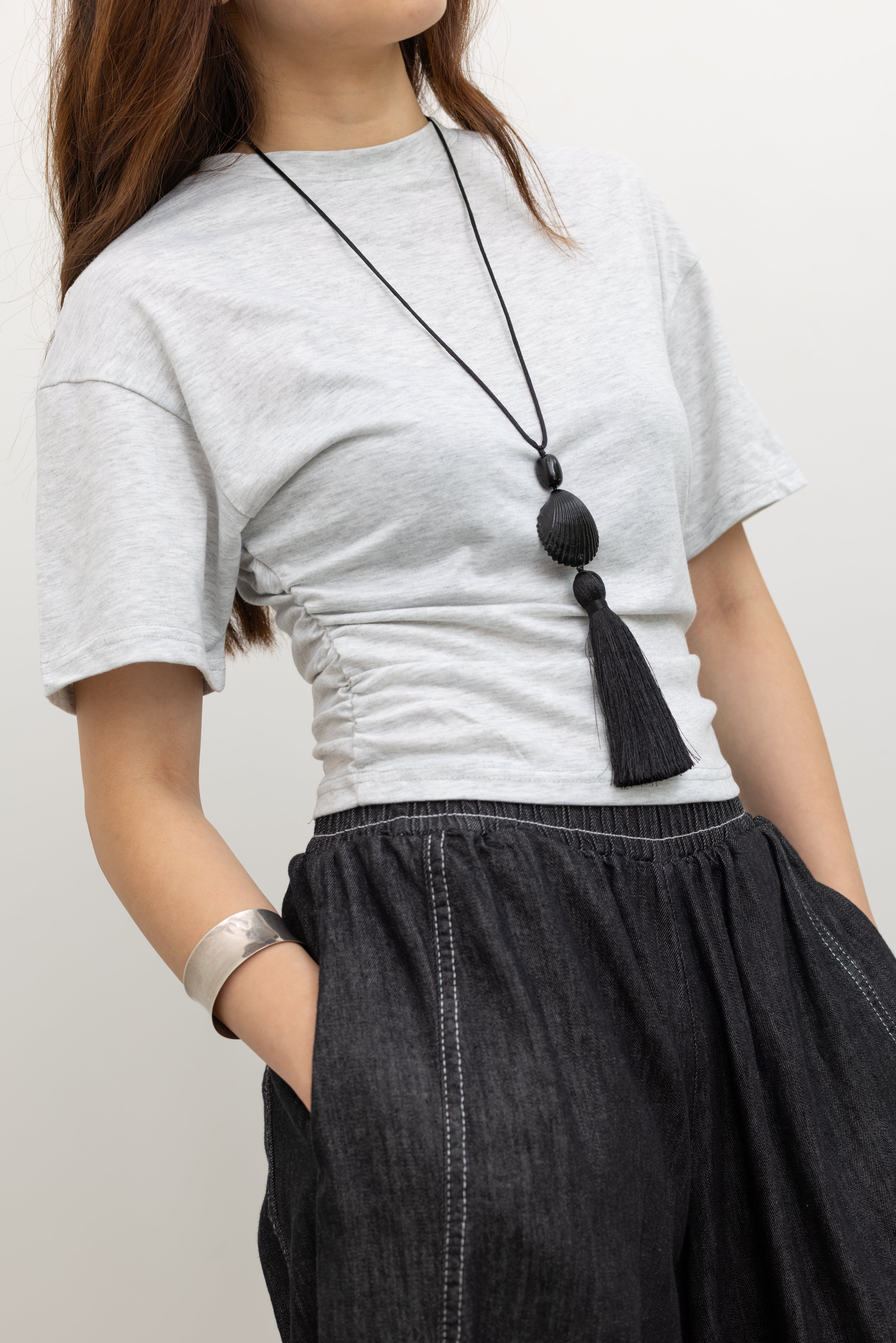 Front view of a woman wearing elevated essential basic t-shirt in a Collective label light gray batwing sleeve cinched waist tee featuring a slim-fit, flattering side-ruching, relaxed drop shoulders and a clean crew neck. Crafted from a soft, fluid stretch blend, it pairs effortlessly Alas Eius label black contrast stitch barrel jeans at Alas Eius.