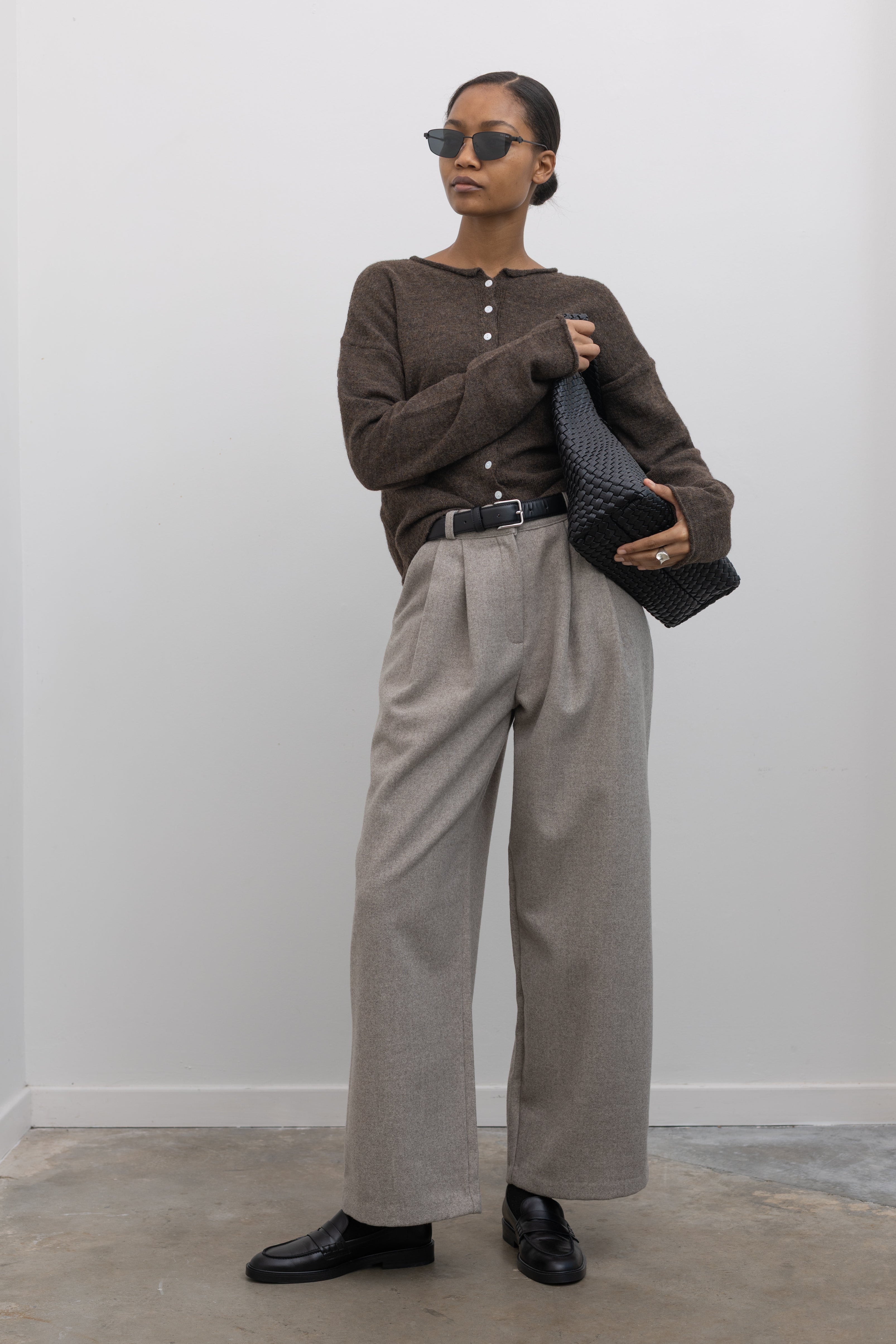 Full length front view of a woman standing wearing sophisticated capsule wardrobe staple in a Collective label Beige Tailored Wool Blend Wide Leg, high rise Pants at Alas Eius. 