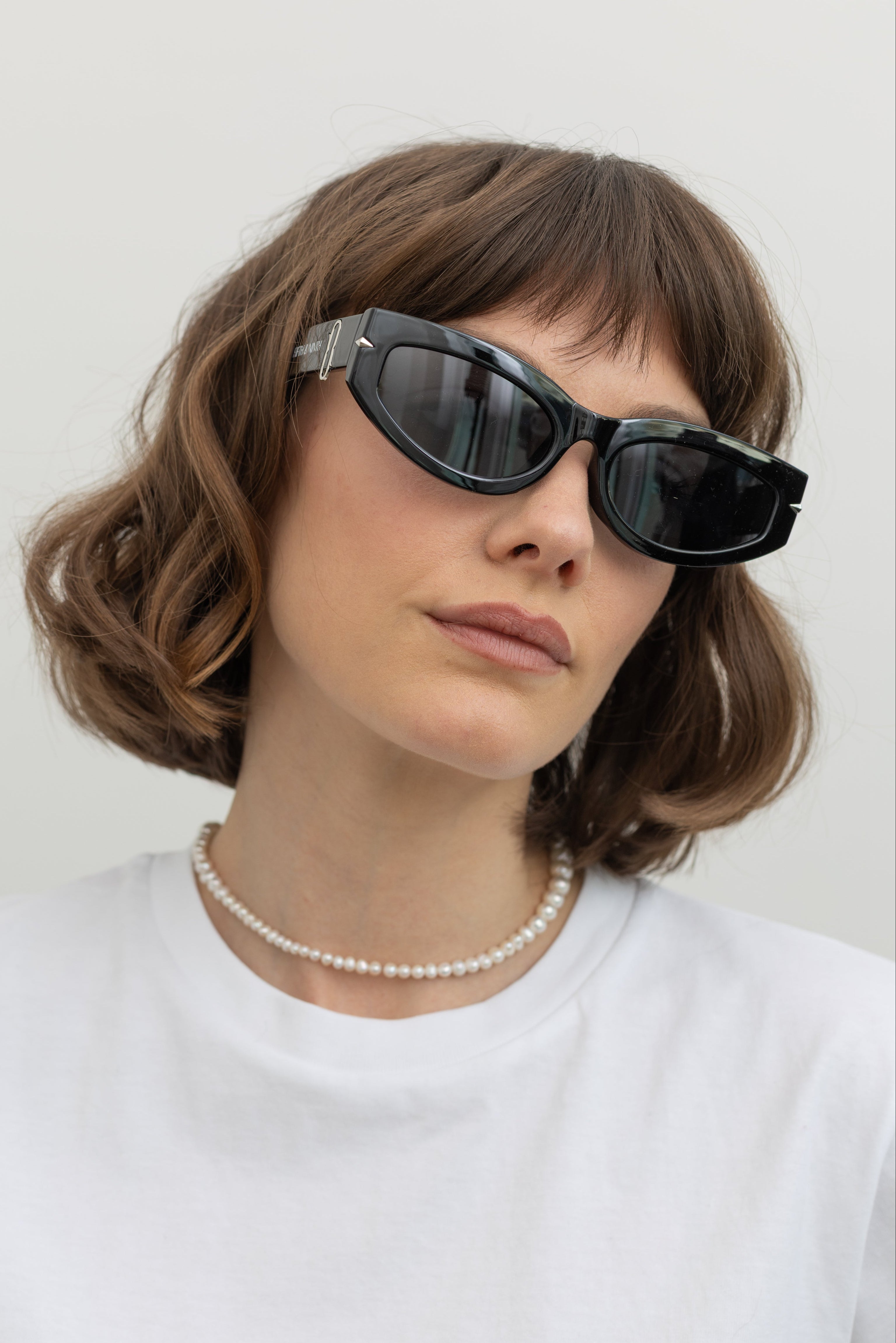 Woman wearing Collective label Black and Silver rectangle thick frame sunglasses at Alas Eius