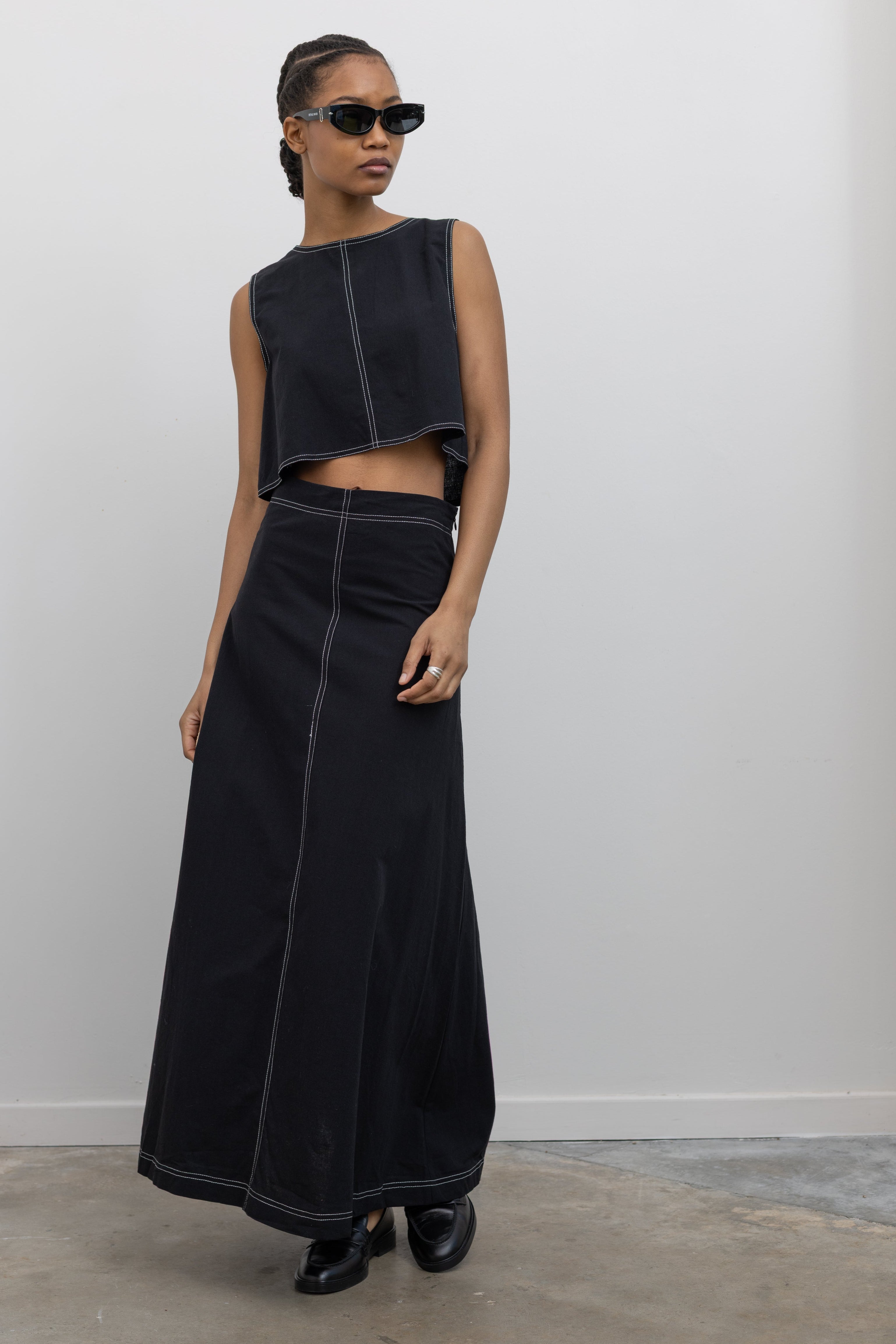Woman wearing Spring fashion in a Collective Black Cotton Linen Contrast Stitch Cropped Top and Black Cotton Linen Contrast Stitch Cropped Maxi Skirt at Alas Eius