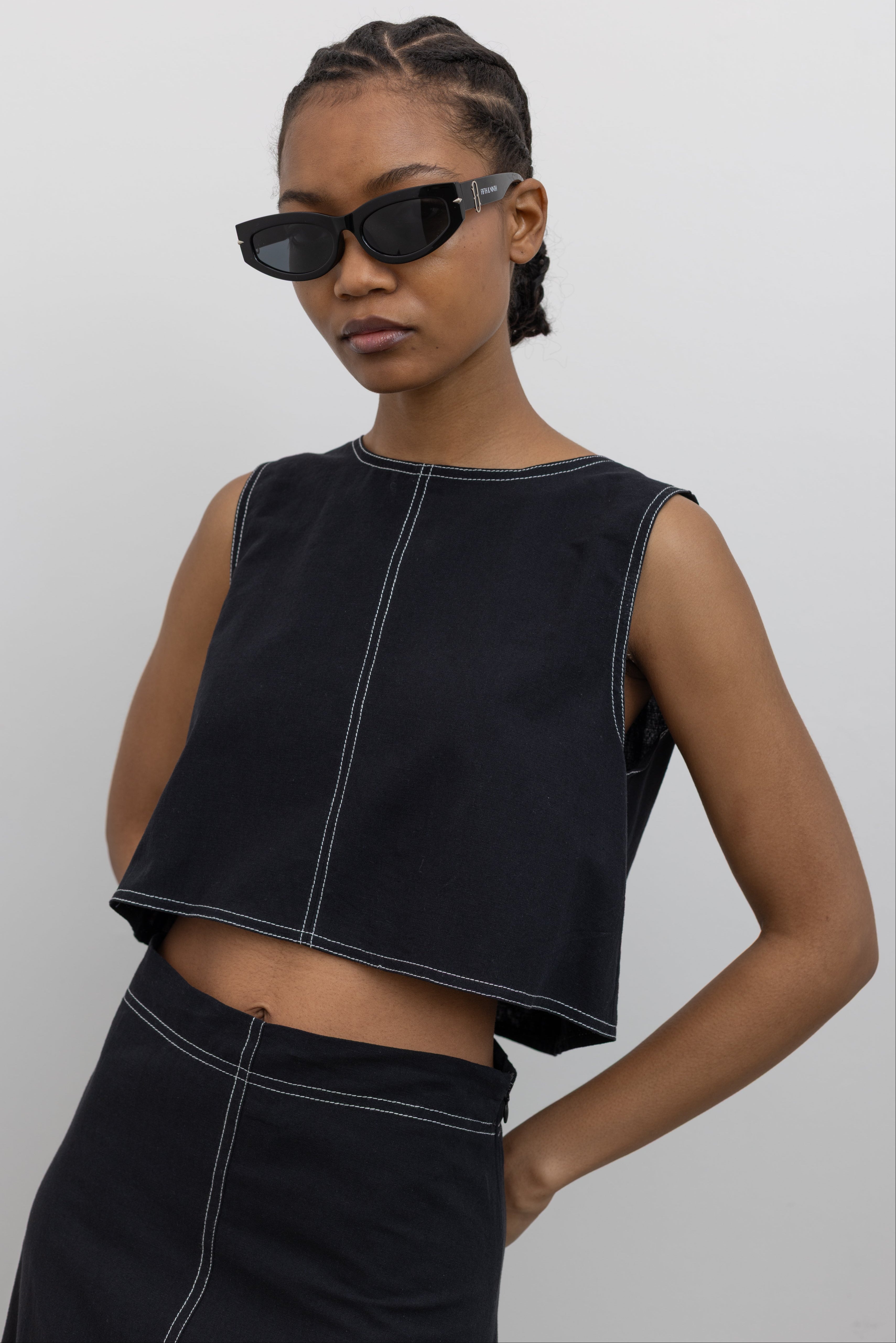 Woman posing with hands behind back wearing Spring fashion in a 
Collective Black Cotton Linen White Contrast Stitch Cropped Top at Alas Eius.