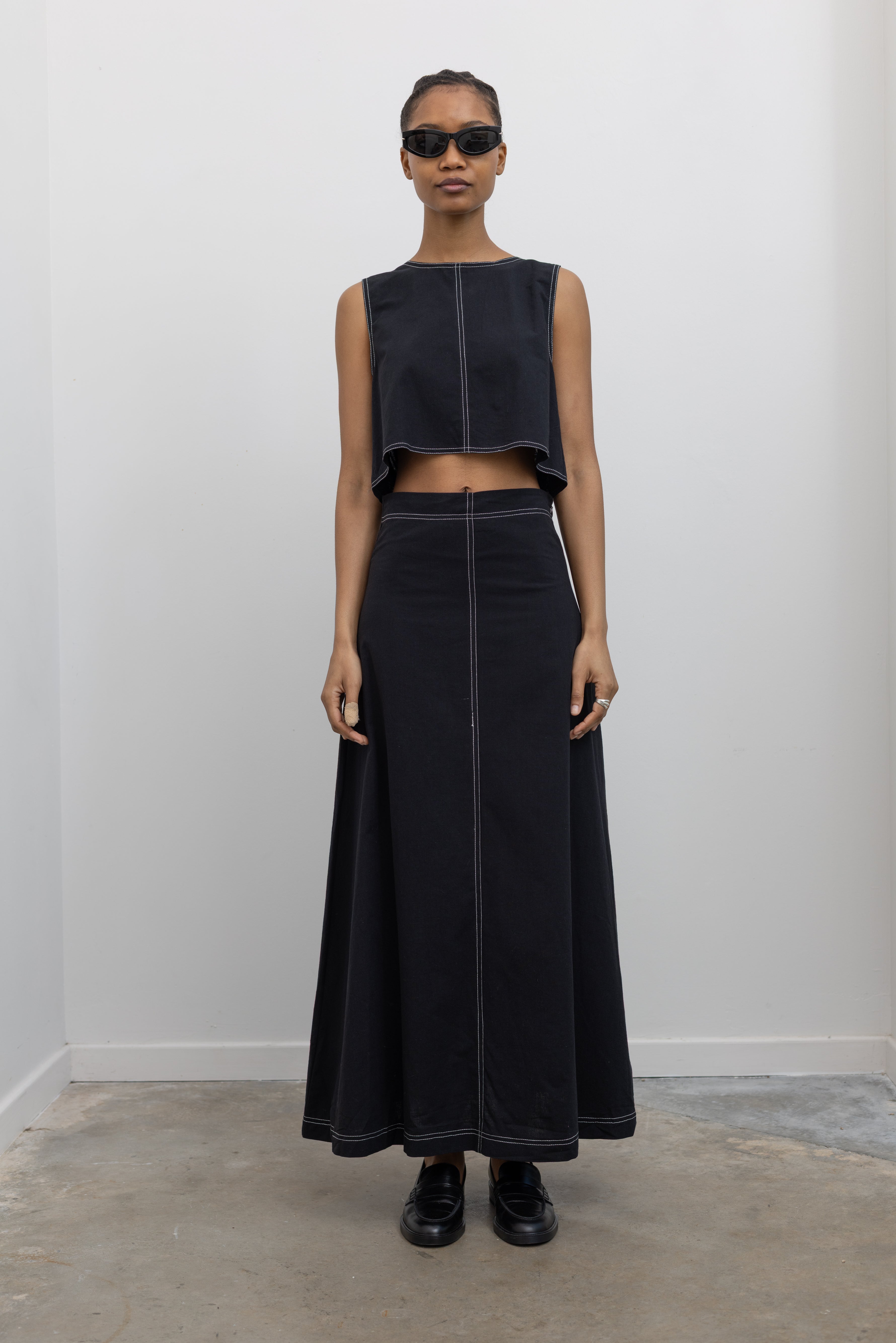 Woman wearing Spring fashion in a Collective Black Cotton Linen Contrast Stitch Cropped Top and Black Cotton Linen Contrast Stitch Cropped Maxi Skirt at Alas Eius