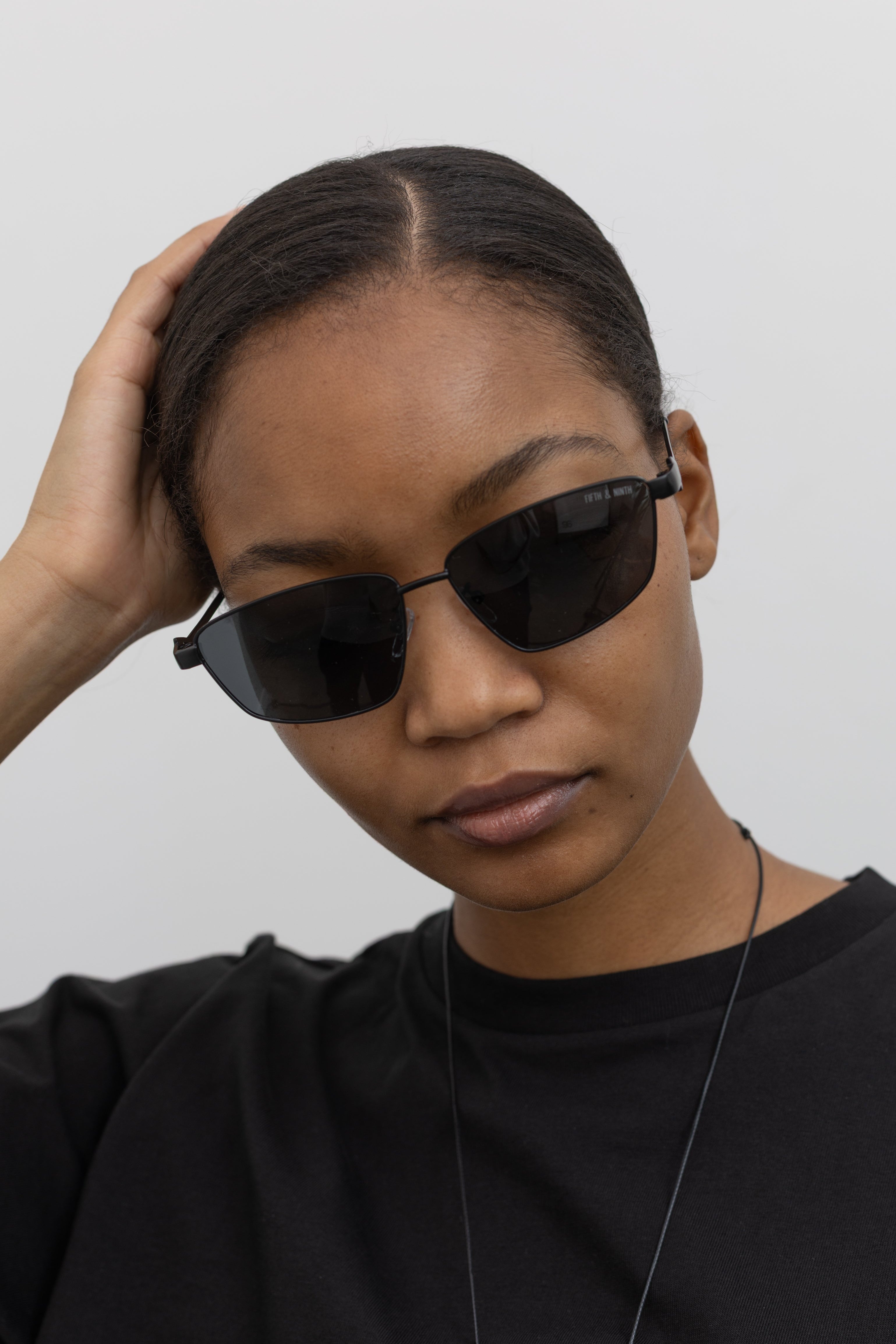 Woman wearing Collective brand black slim metal frame sunglasses at Alas Eius.