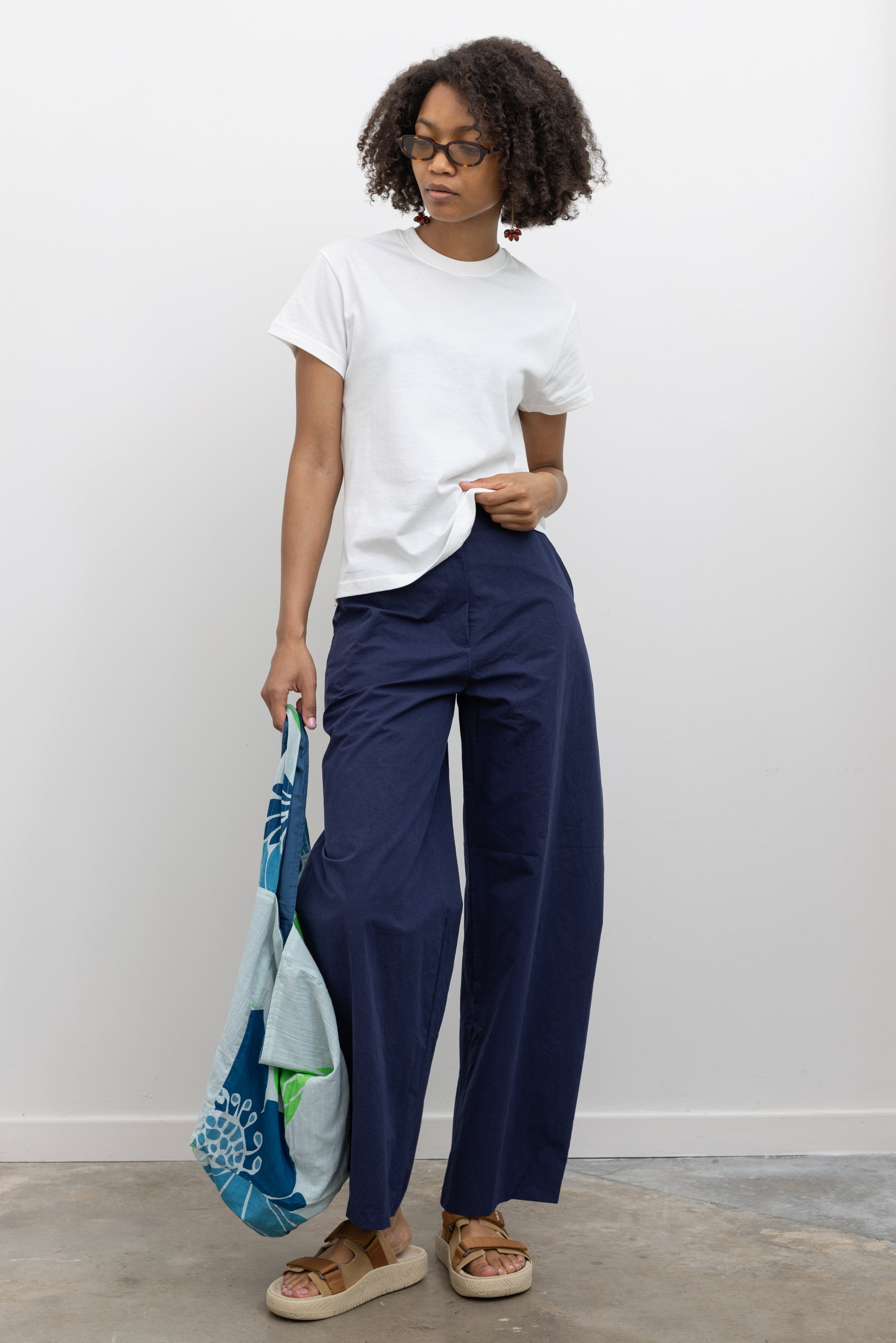 Elevated summer fashion in Collective blue cotton barrel-leg pants with a relaxed curved fit and wide-leg silhouette paired with a white tee at Alas Eius.