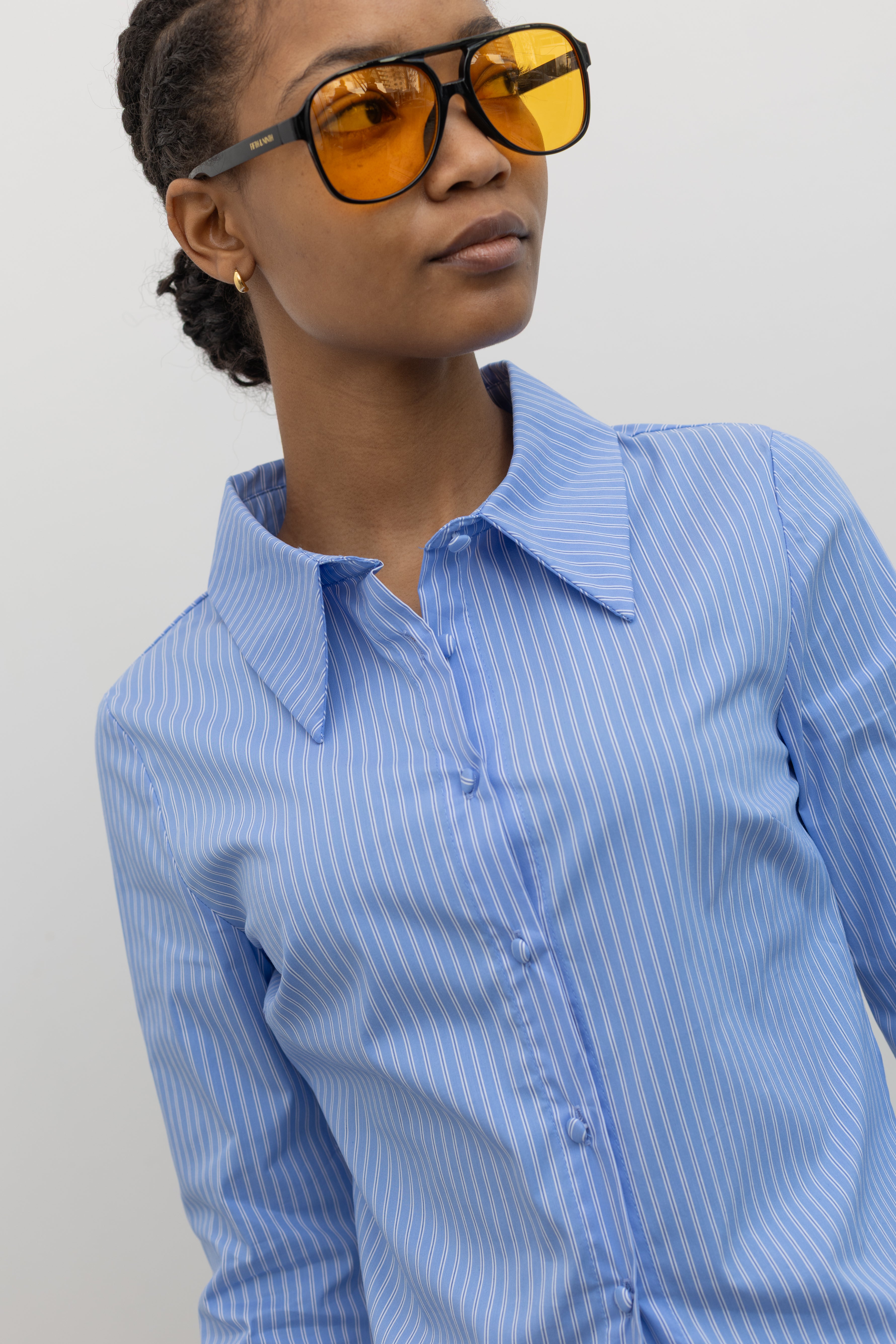 Close-up product view of a woman wearing Spring fashion in a Collective Blue Pinstripe Tailored Slim-Fit Button Down Collared Shirt at Alas Eius.