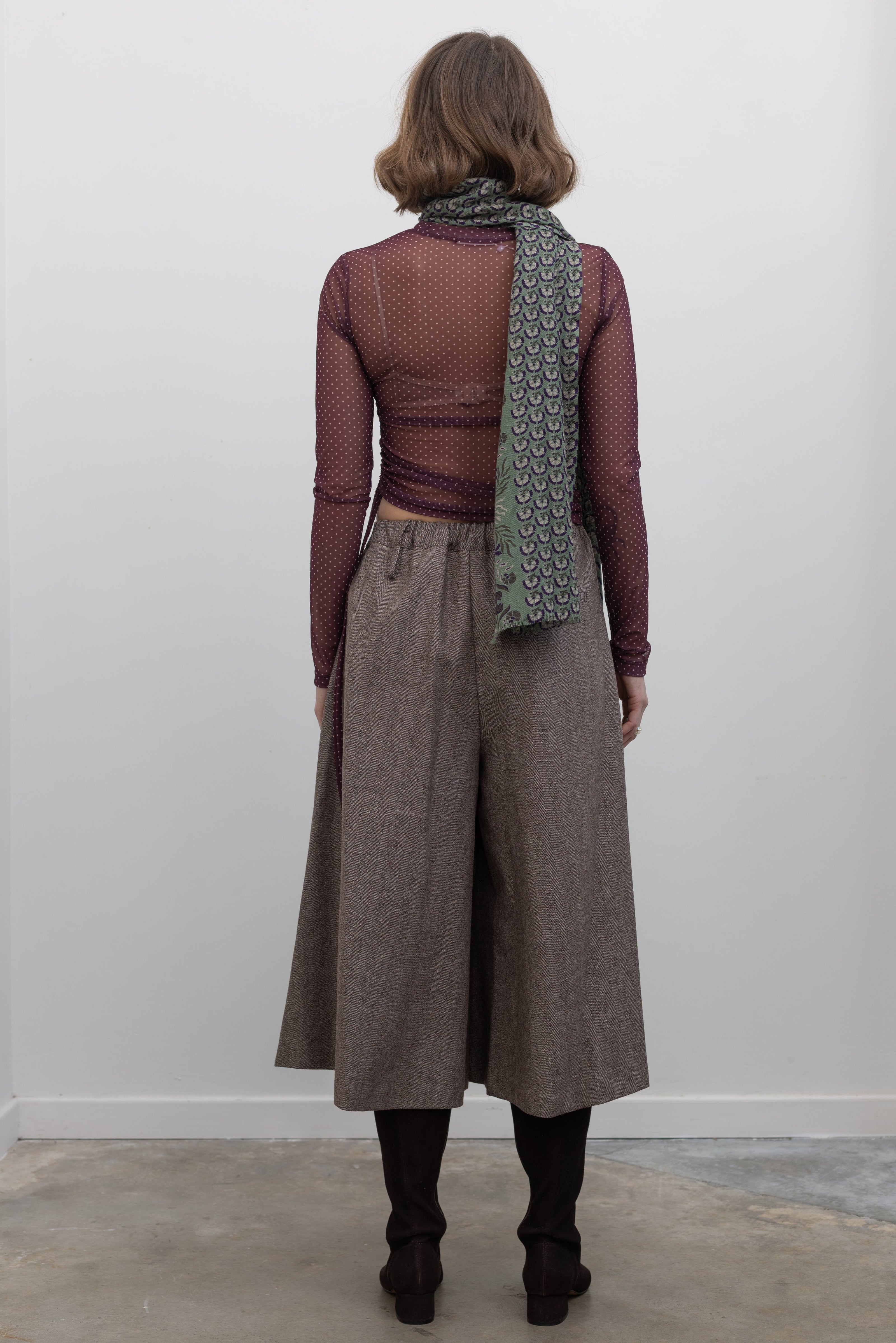 Back view of a woman wearing Collective Brown wool Herringbone Wide Leg Culotte Pants at Alas Eius