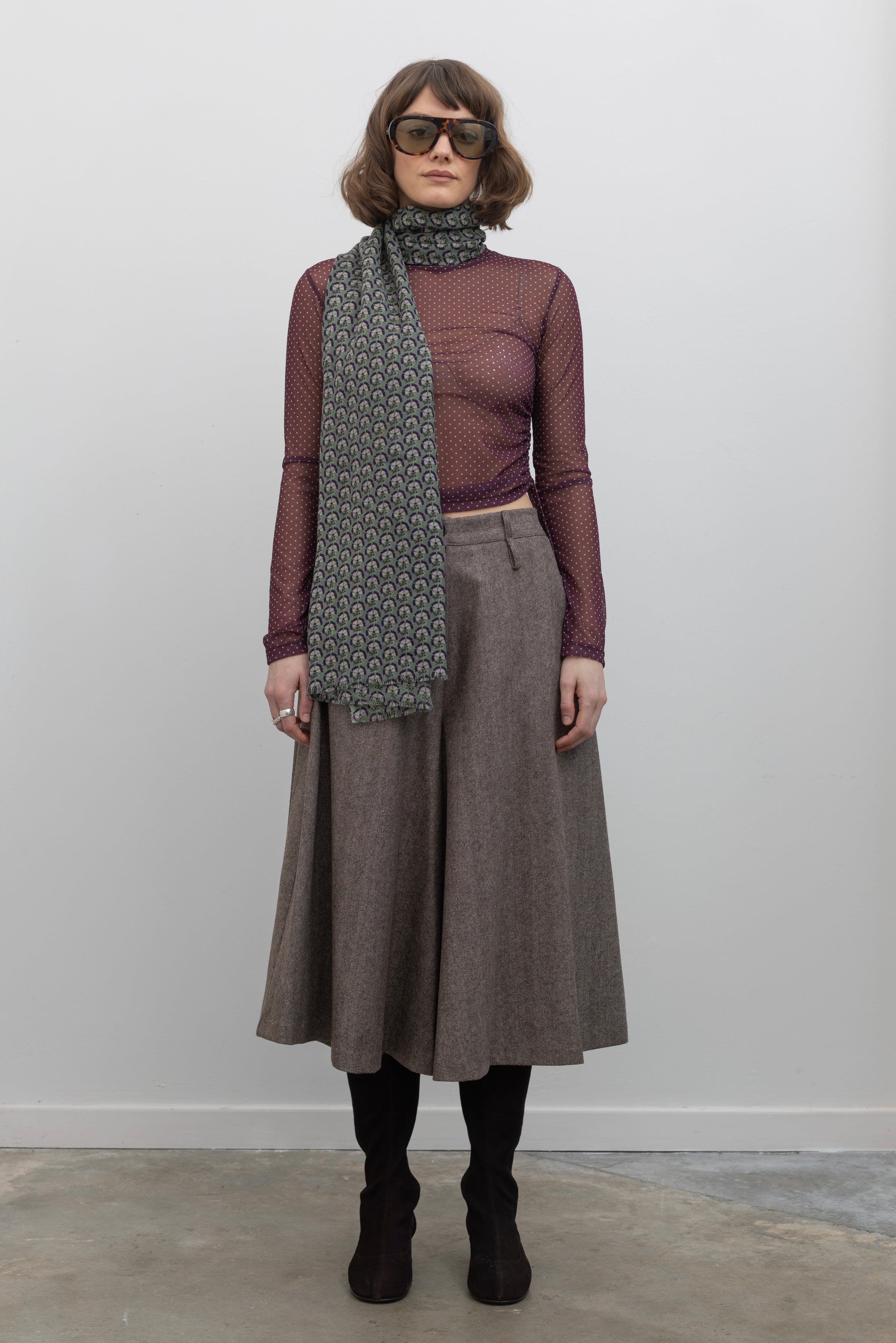 Full length view of a Woman wearing Collective Brown wool Herringbone Wide Leg Culotte Pants with a Les Belles Vagabondes brand Marigold green wool printed scarf at Alas Eius.