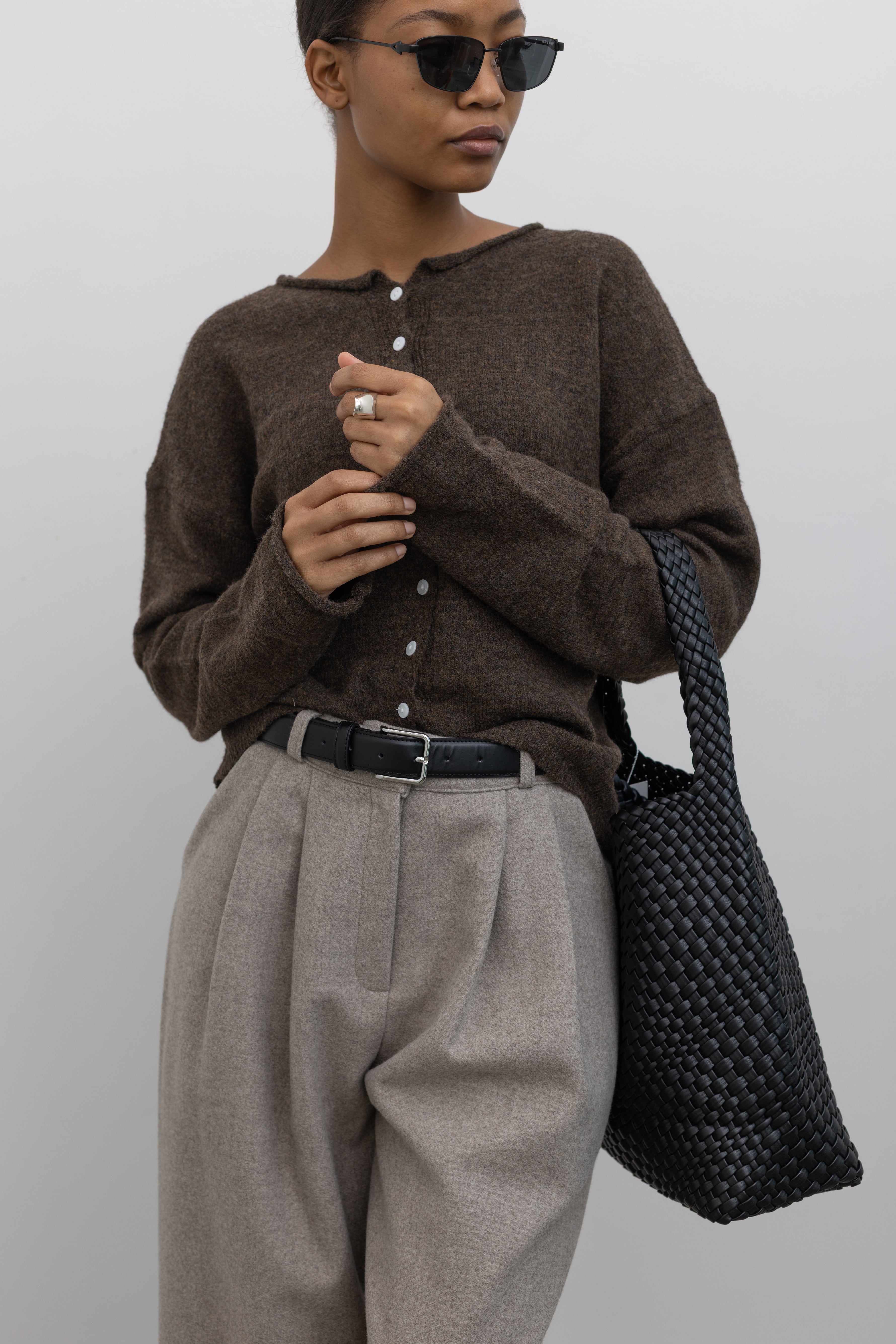 Collective Classic Black Leather belt with silver square buckle paired with a classic wool button front cardigan and gray pleated trousers at Alas Eius 