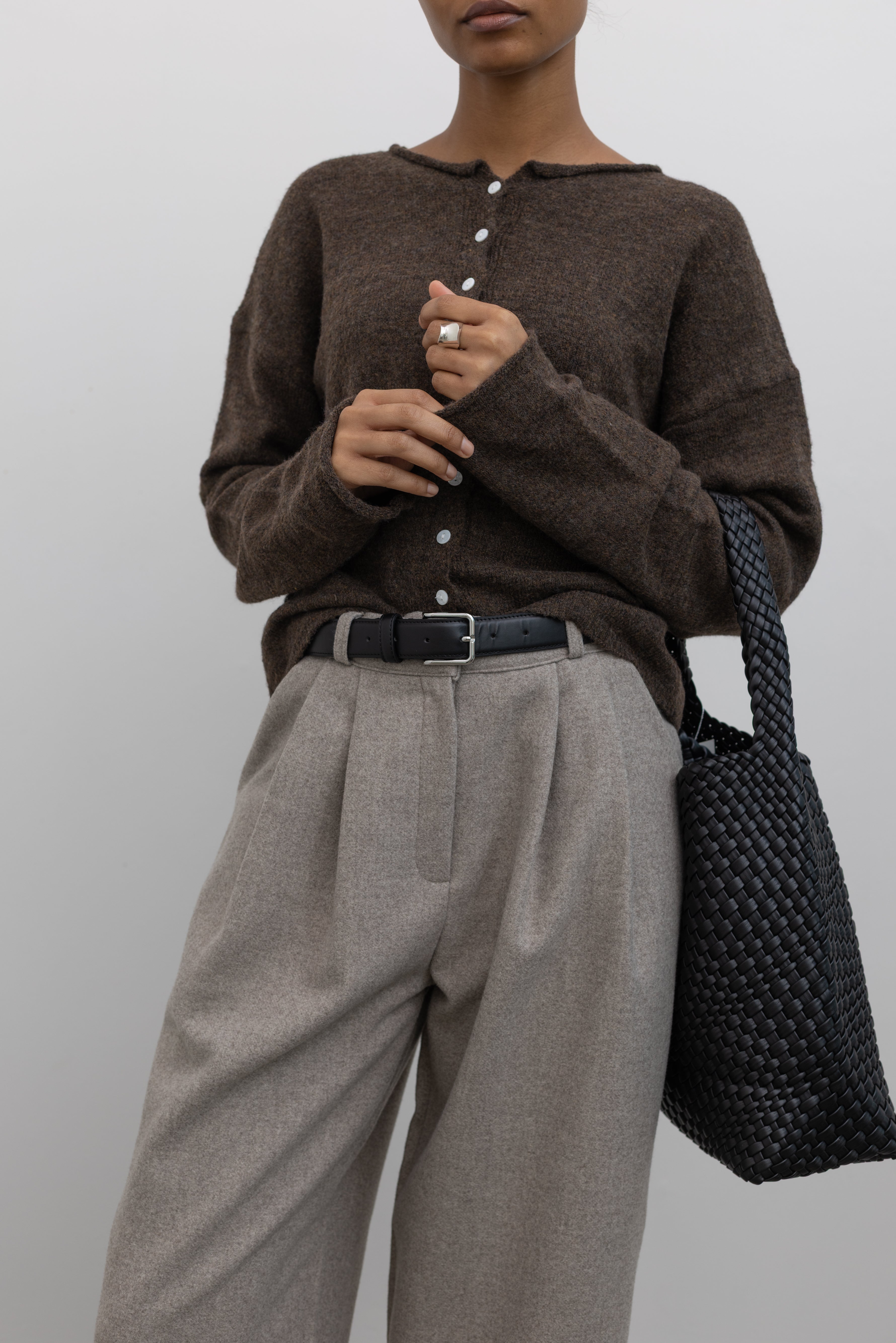 Collective Classic Black Leather belt with silver square buckle paired with a classic wool button front cardigan and gray pleated trousers at Alas Eius 