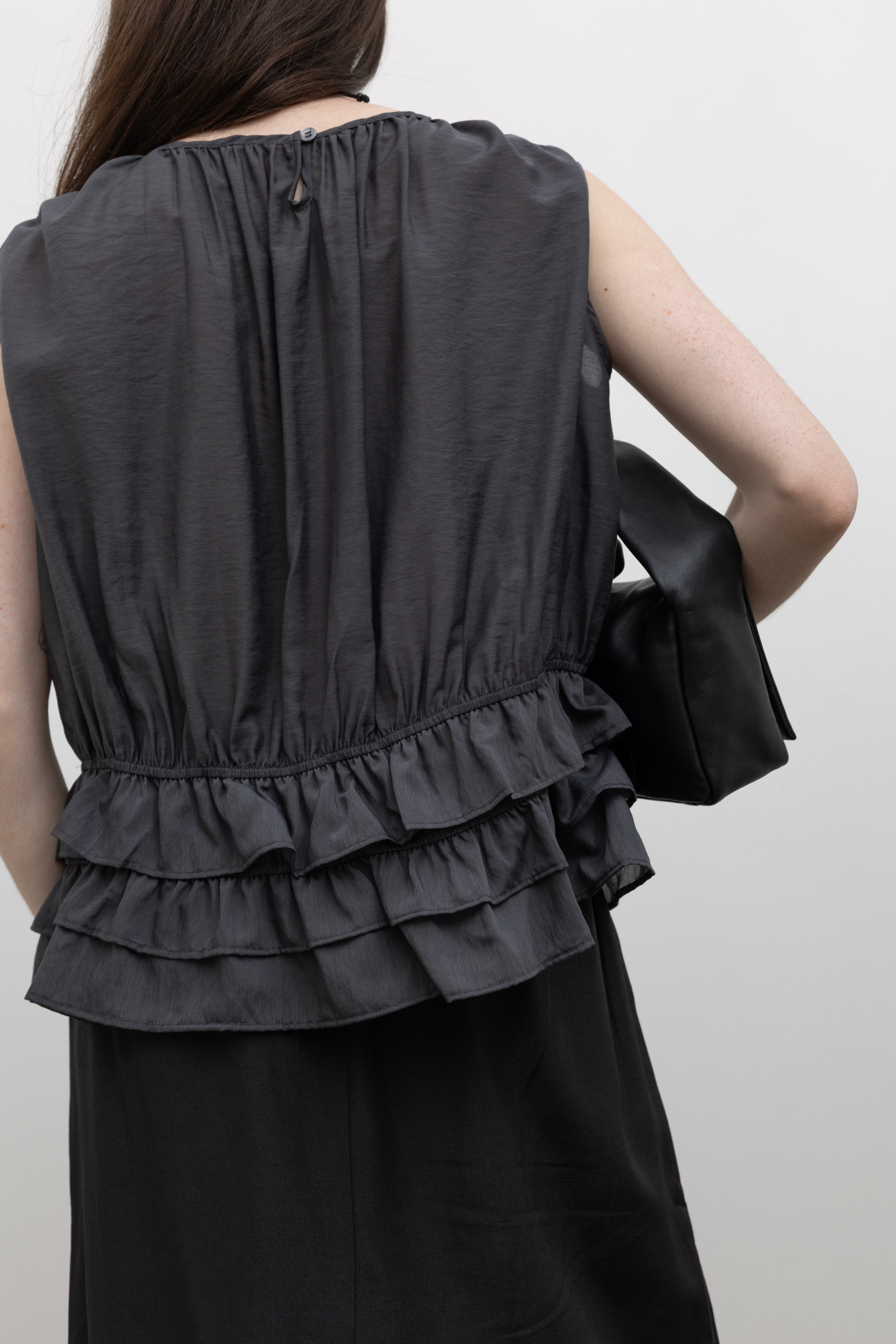 Collective charcoal Tencel blouse with gathered neckline, fluid sleeveless silhouette, and elasticated waist creating a softly structured feminine shape for versatile styling at Alas Eius