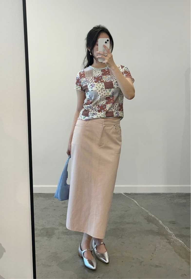 Full length front view of a Woman wearing a Collective Quilted Pattern Floral Tee Shirt with midi skirt at Alas Eius