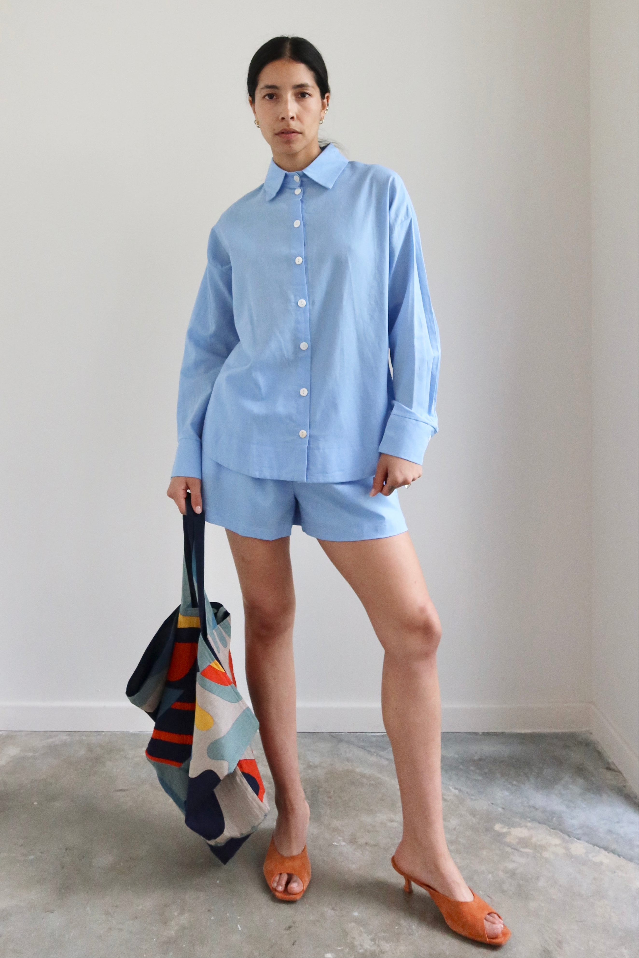 Woman wearing contemporary Spring / Summer fashion in a pair of Collective Light Blue Cotton Pull On Shorts at Alas Eius. 