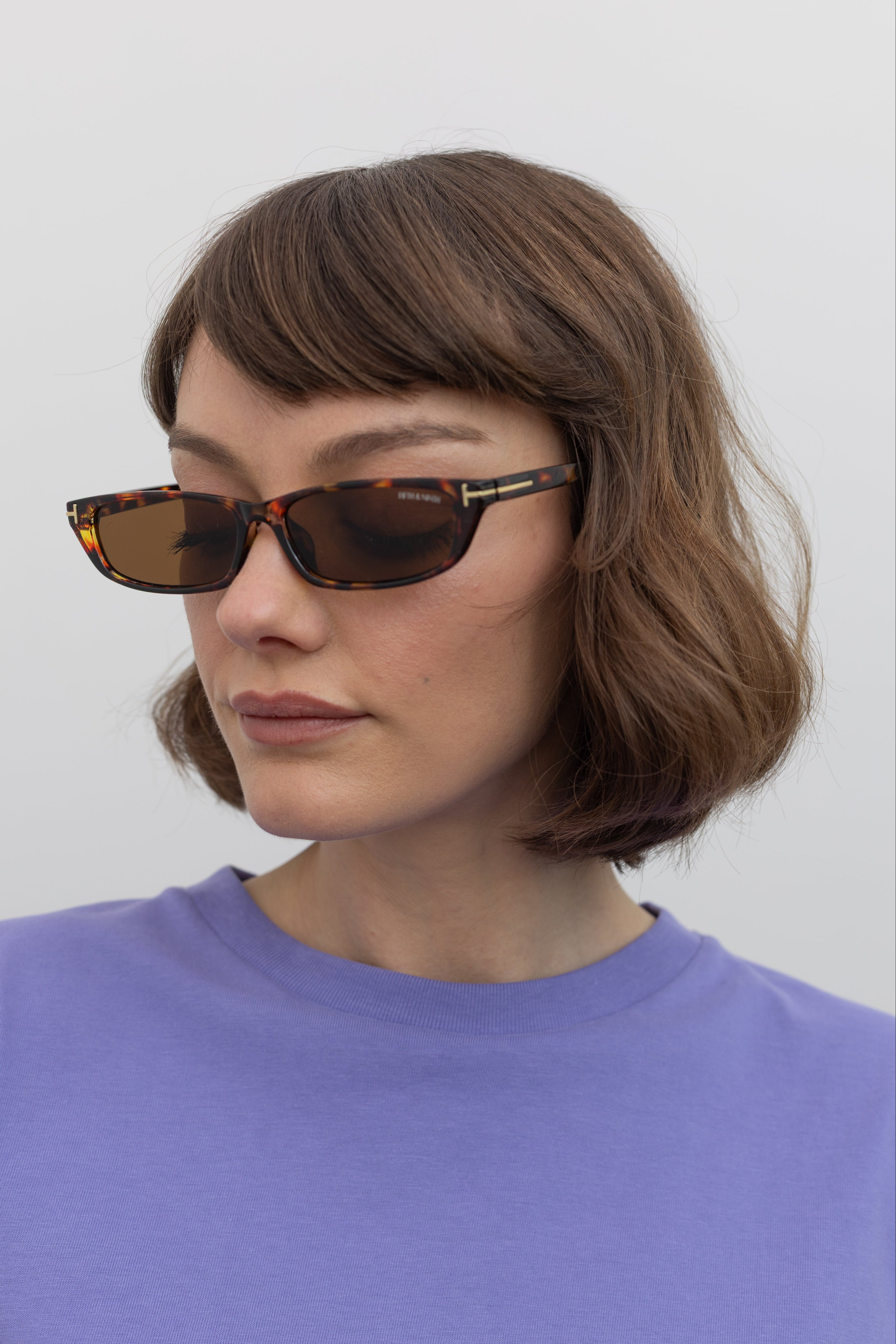 Woman wearing sleek and modern Collective brand Tortoise Slim Rectangle Sunglasses with 100% UV protection at Alas Eius