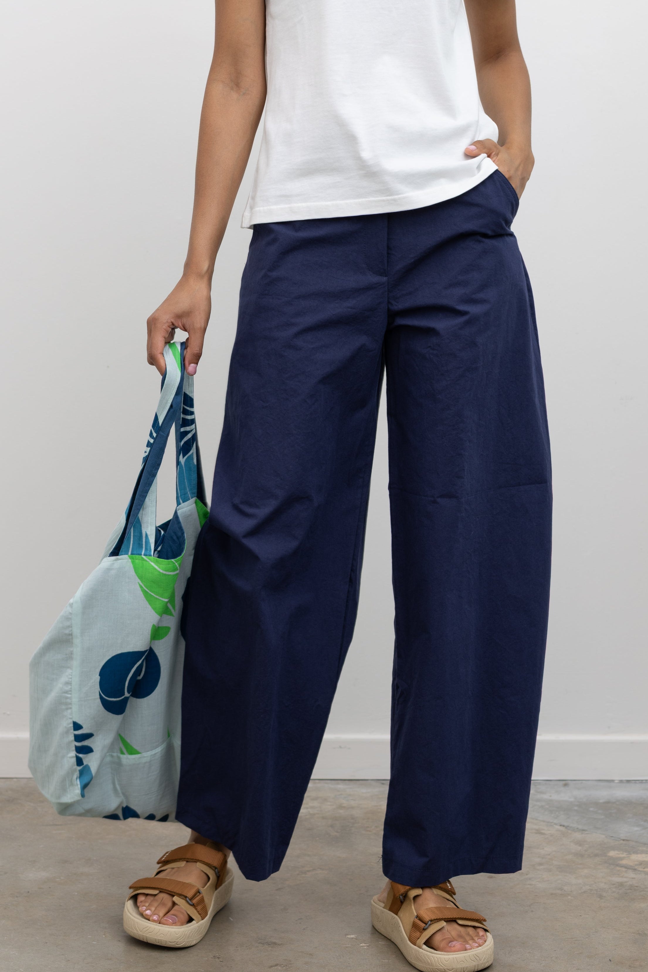 Elevated summer fashion in Collective blue cotton barrel-leg trouser with a relaxed curved fit and cropped hem paired with a white tee at Alas Eius.