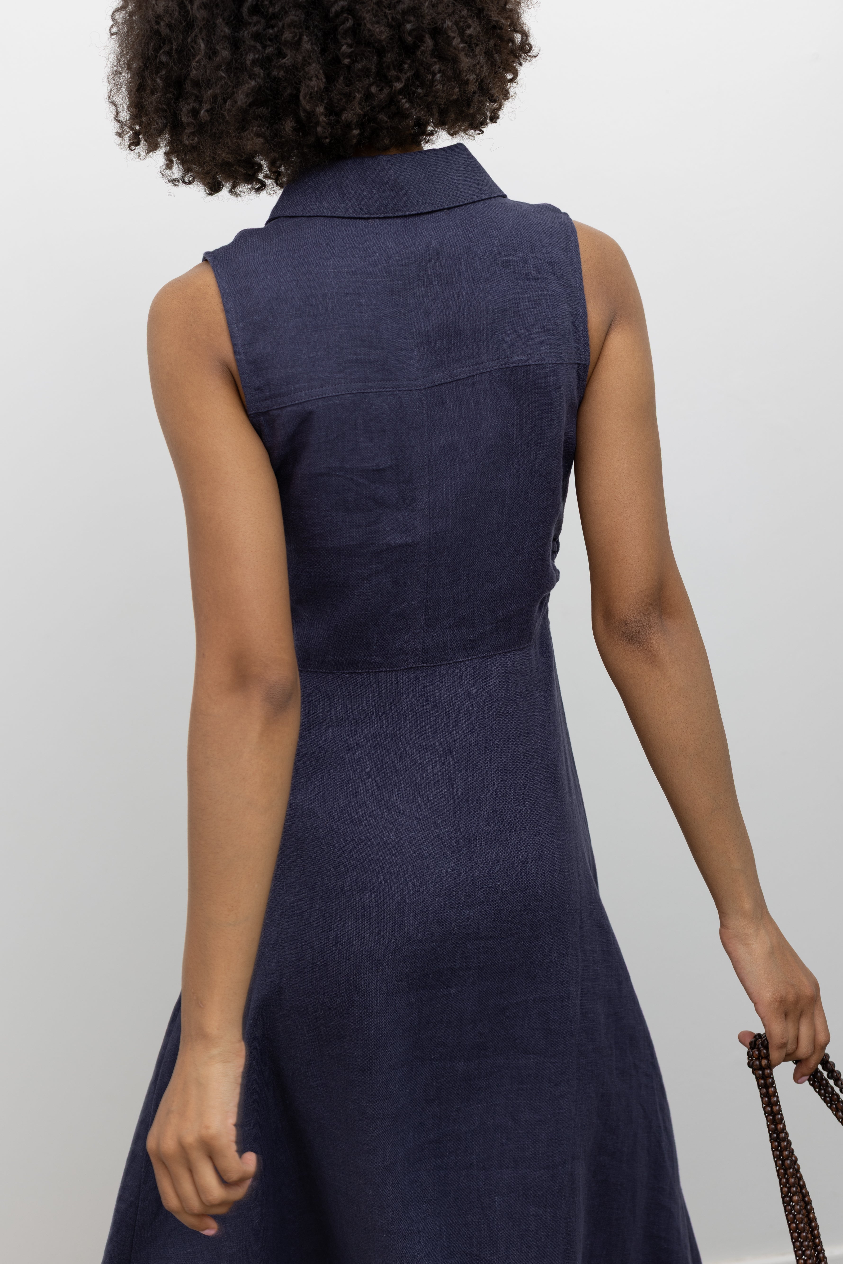 Collective SS26 navy blue linen sleeveless collared midi length shirt dress with cinched side seam detail at Alas Eius.