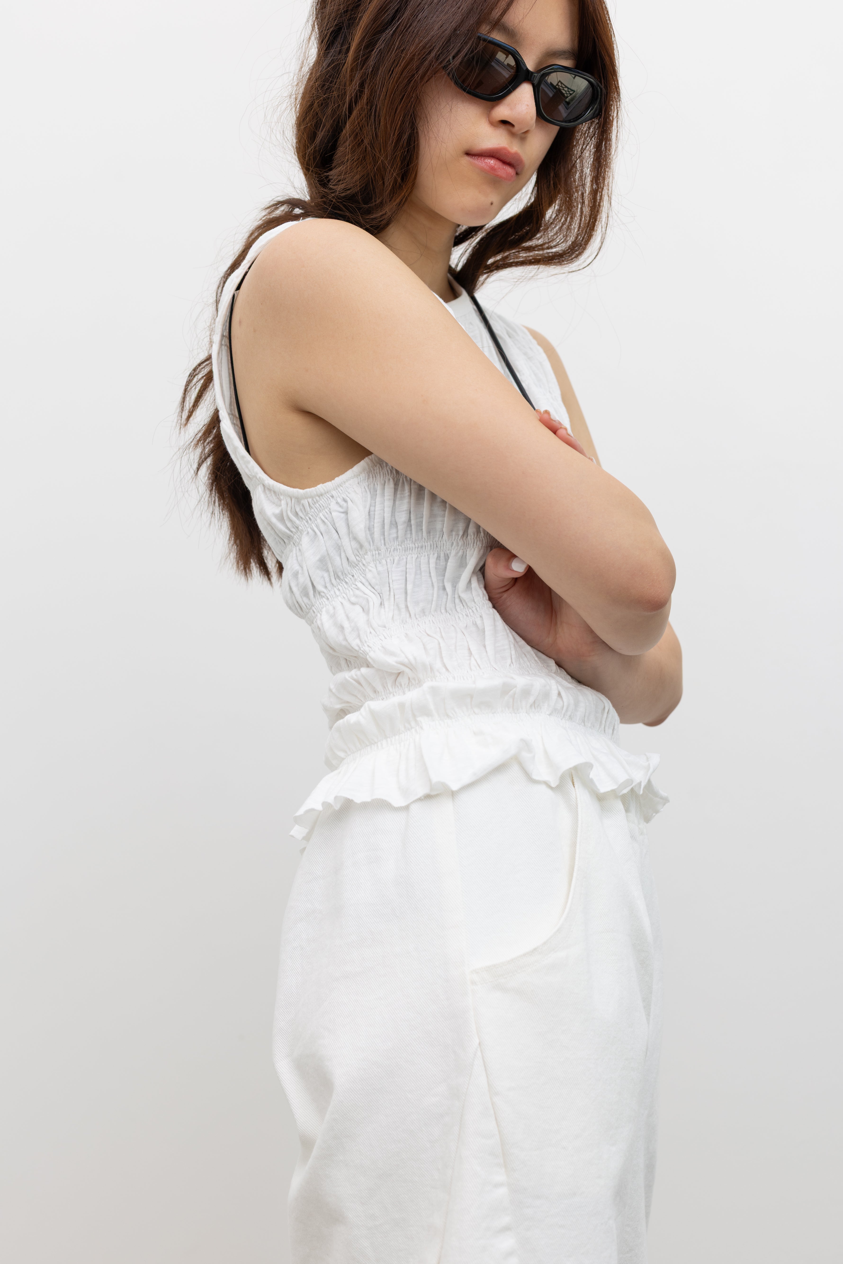 Collective High-neck sleeveless top with flexible smocked texture and soft flared hem at Alas Eius