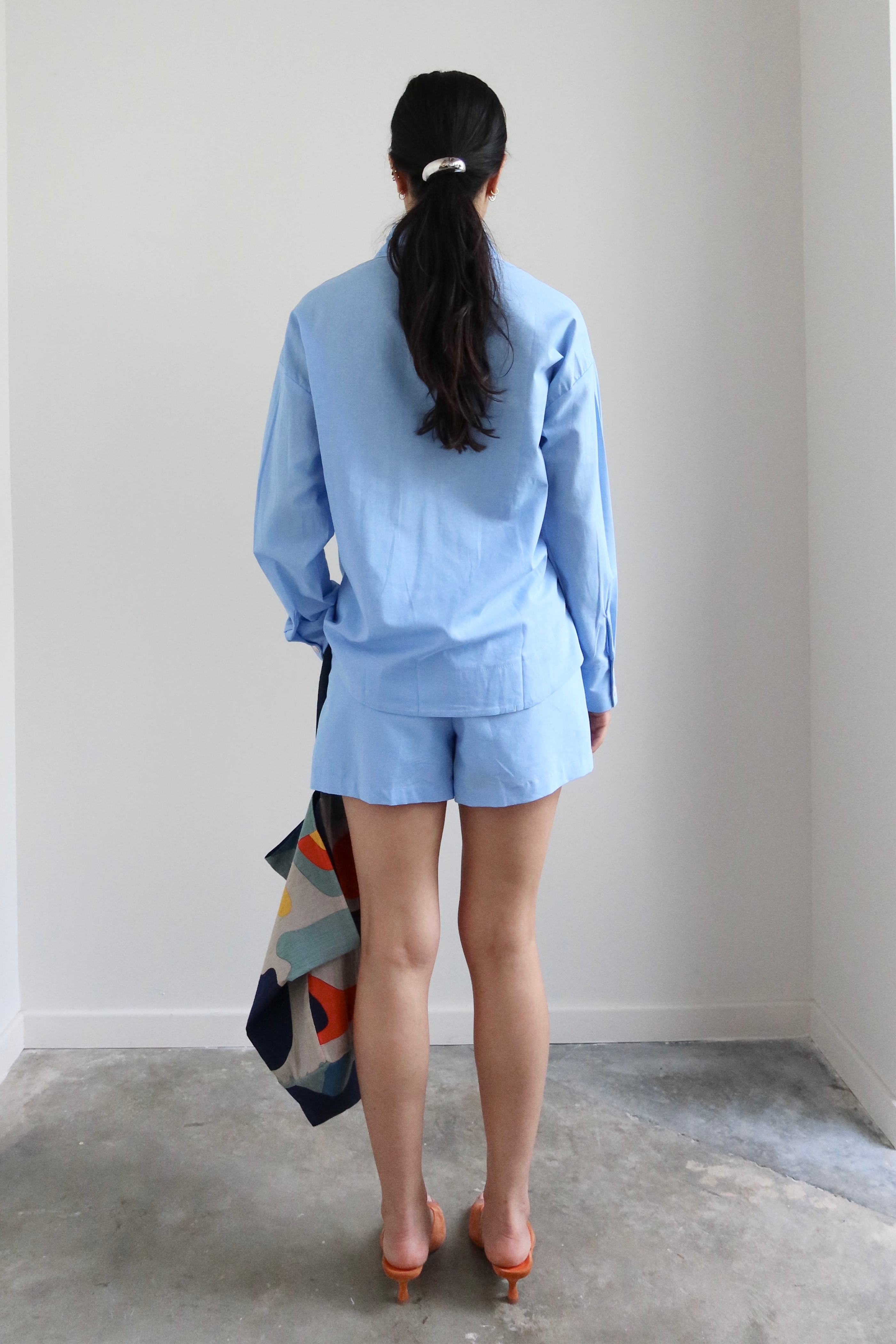 Full length back view of a woman wearing Spring / Summer fashion in a pair of Collective Light Blue Cotton Pull On Shorts at Alas Eius. 