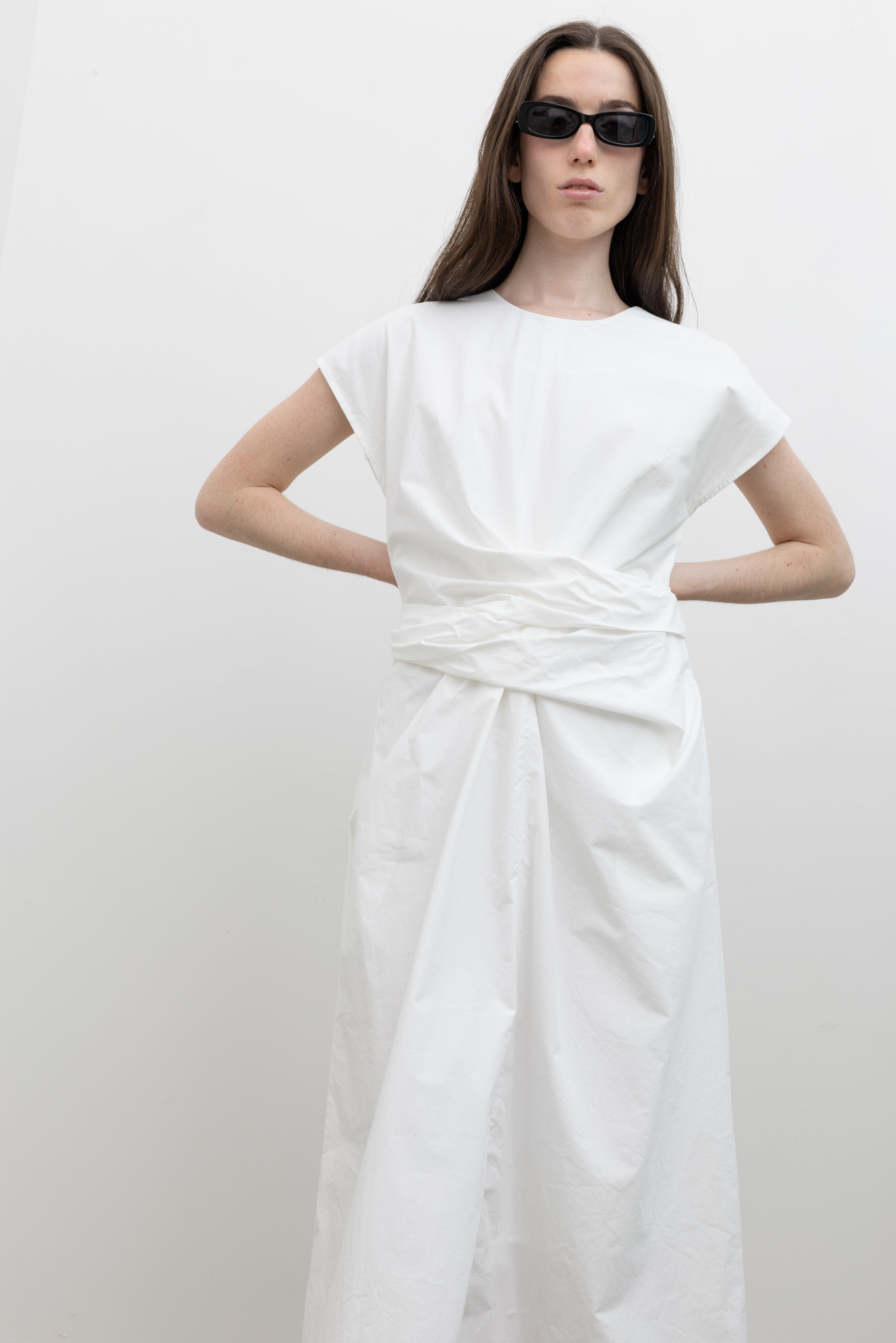 Tailored cotton midi dress by Collective featuring cap sleeves, side pockets, a buttoned back neck, and a self-fabric tie waist allowing for a cinched or relaxed fit at Alas Eius.