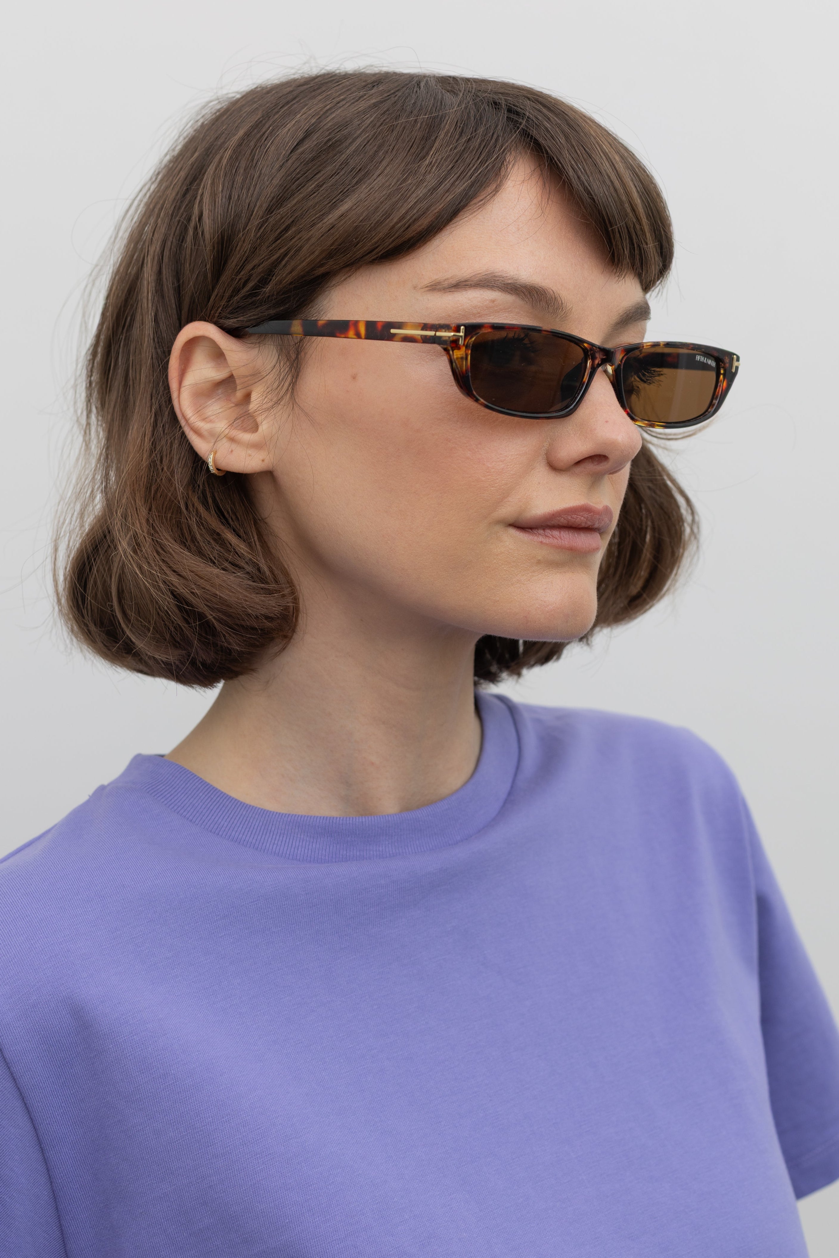 Woman wearing sleek and modern Collective brand Tortoise Slim Rectangle Sunglasses with 100% UV protection at Alas Eius