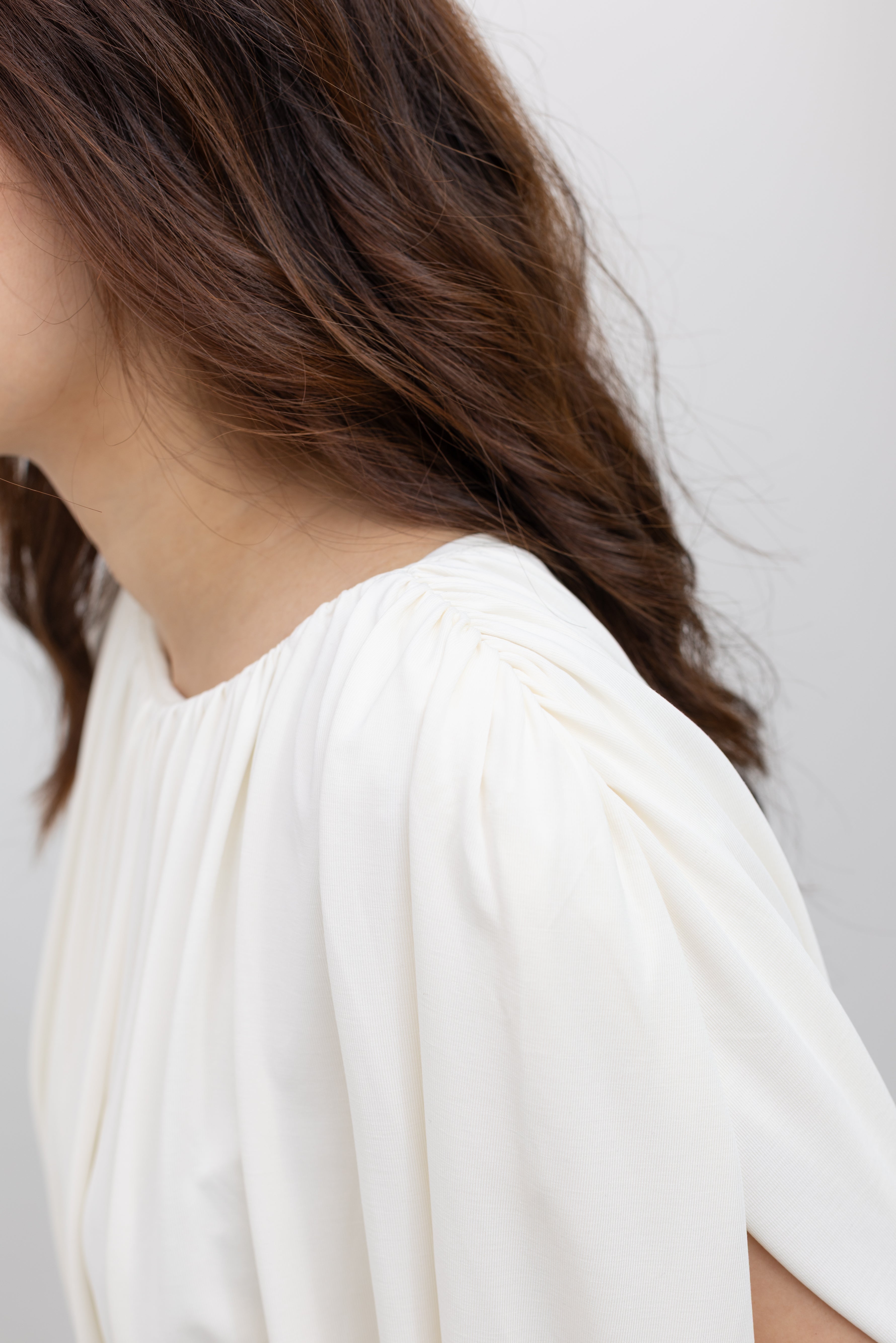 Detailed view of the Collective white pleated balloon top with all-over gathers, a voluminous puff cropped hem, and a fully lined relaxed silhouette at Alas Eius. 