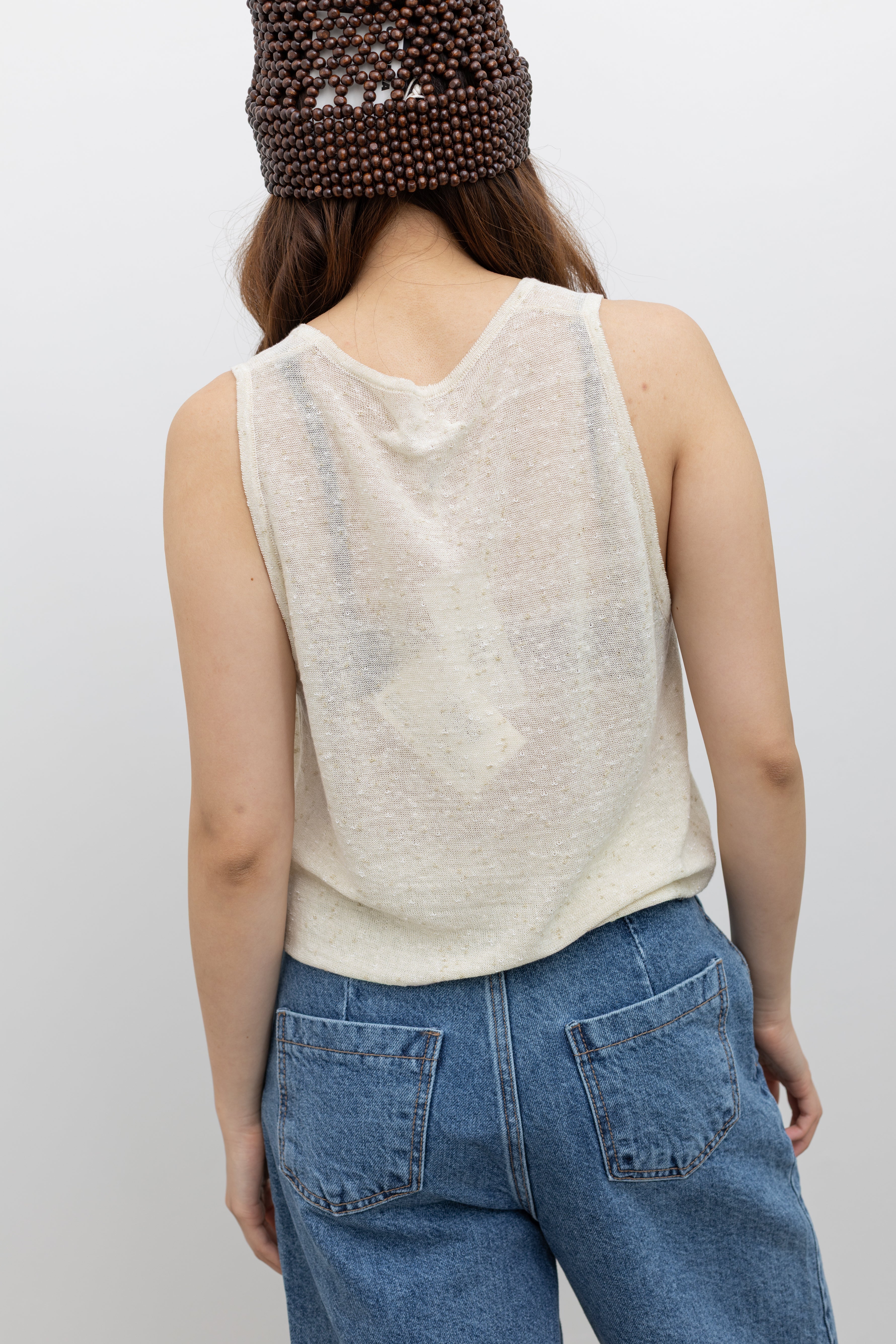 Model wearing seasonless wardrobe essential Cordera sleeveless oversized cream top in textured linen and cotton blend designed for effortless everyday wear at Alas Eius. 