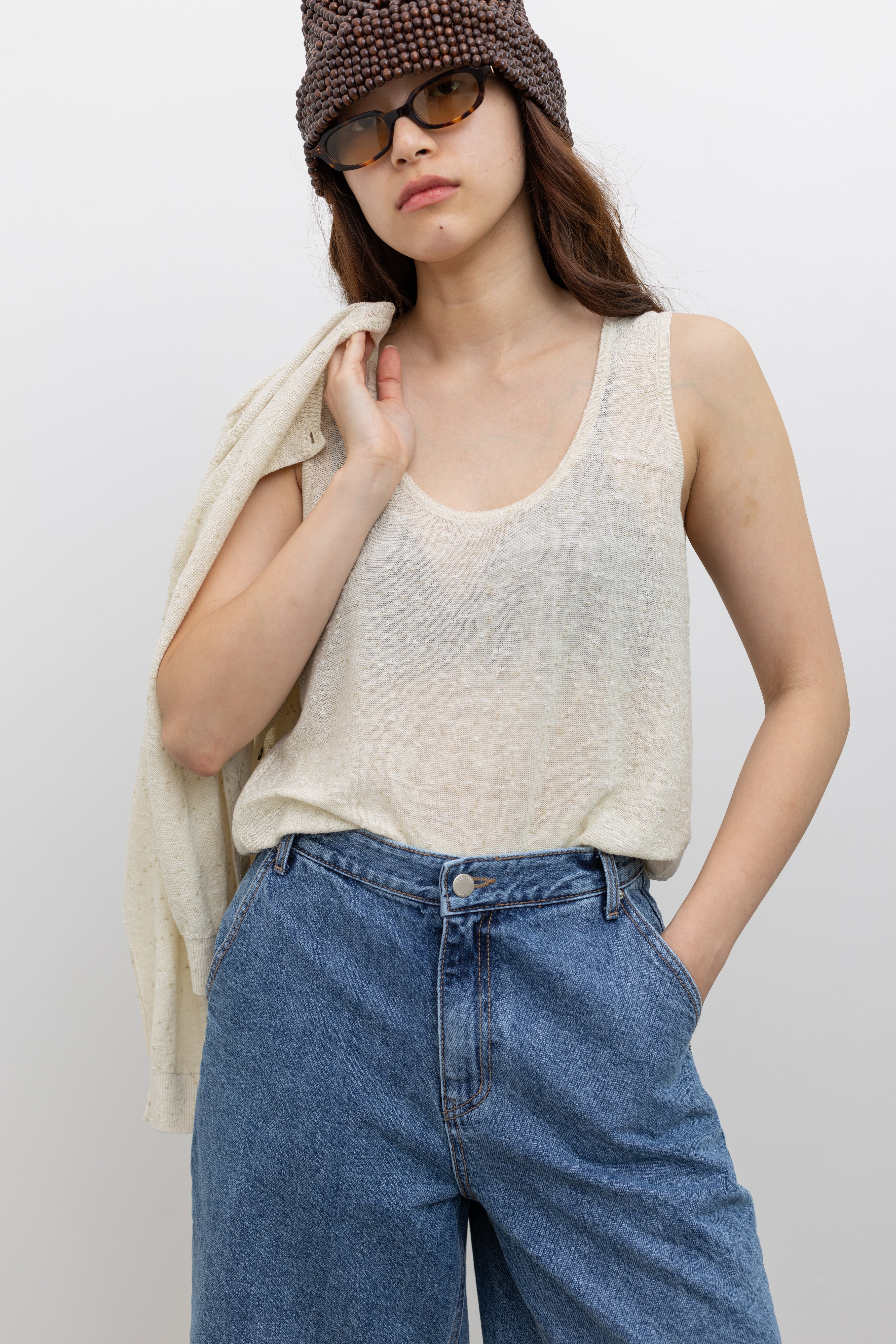 Model wearing timeless women’s fashion in a Cordera oversized cream tank top in a flecked linen and cotton blend with a relaxed sleeveless silhouette at Alas Eius 