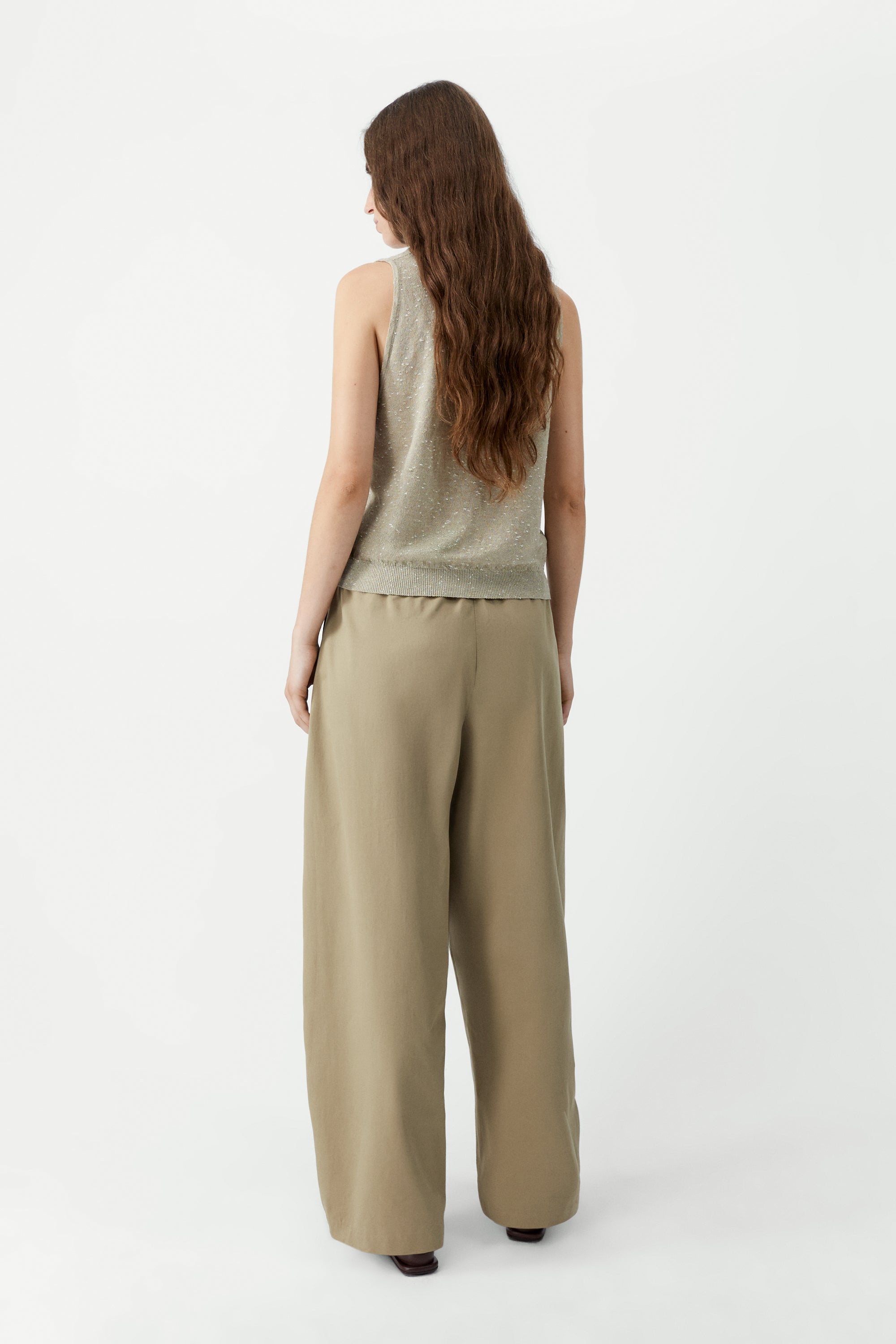 Full length back view of a woman standing wearing a versatile spring layering essential in the Cordera beige linen and cotton blend flecked tank top at Alas Eius.

This cardigan is ethically and carefully manufactured in La Coruña, with Japanese knitting machines and finished by hand. Made in Spain.