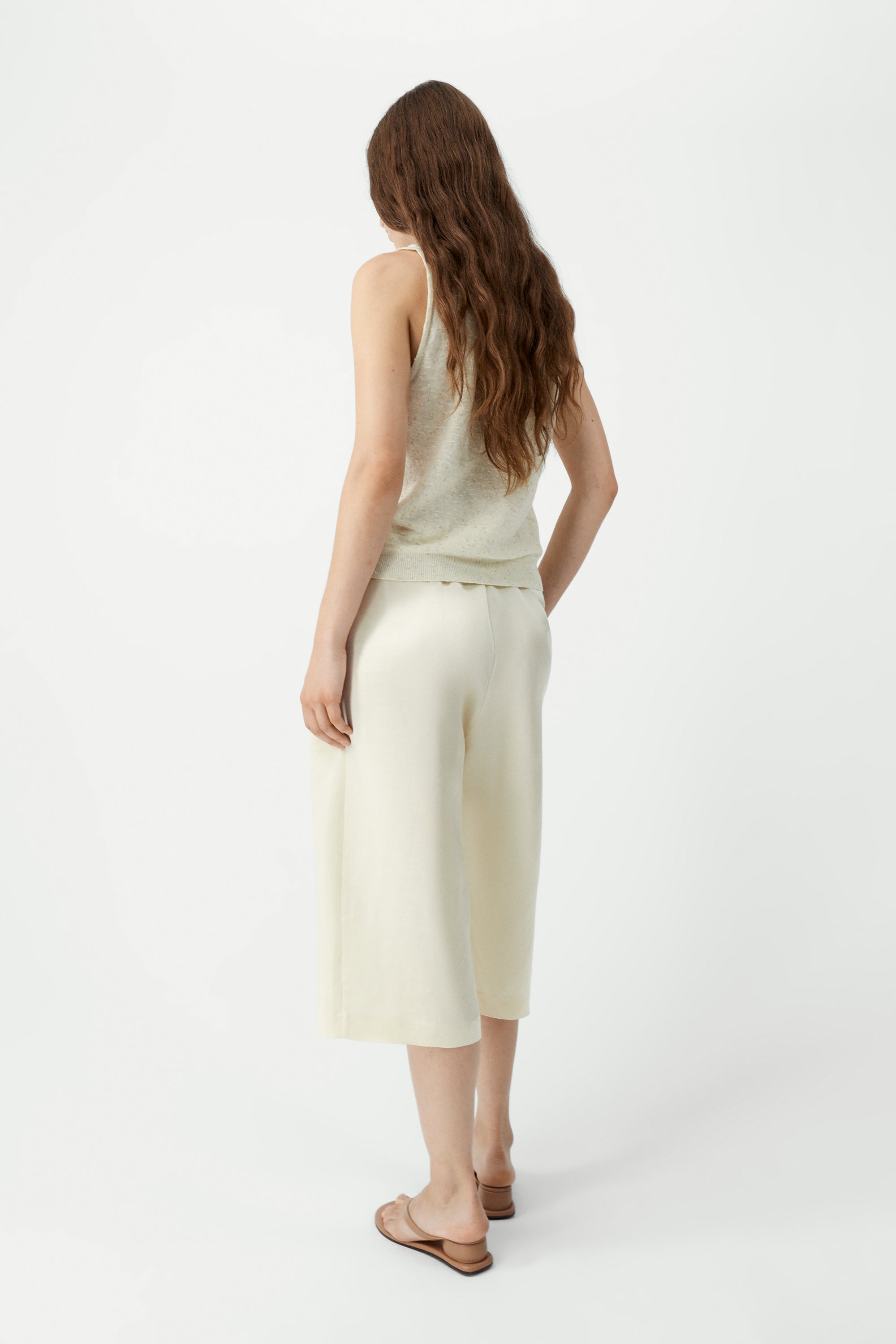 Full length front view of a woman standing wearing a versatile spring layering essential in the Cordera cream linen and cotton blend flecked tank top at Alas Eius.

This cardigan is ethically and carefully manufactured in La Coruña, with Japanese knitting machines and finished by hand. Made in Spain.