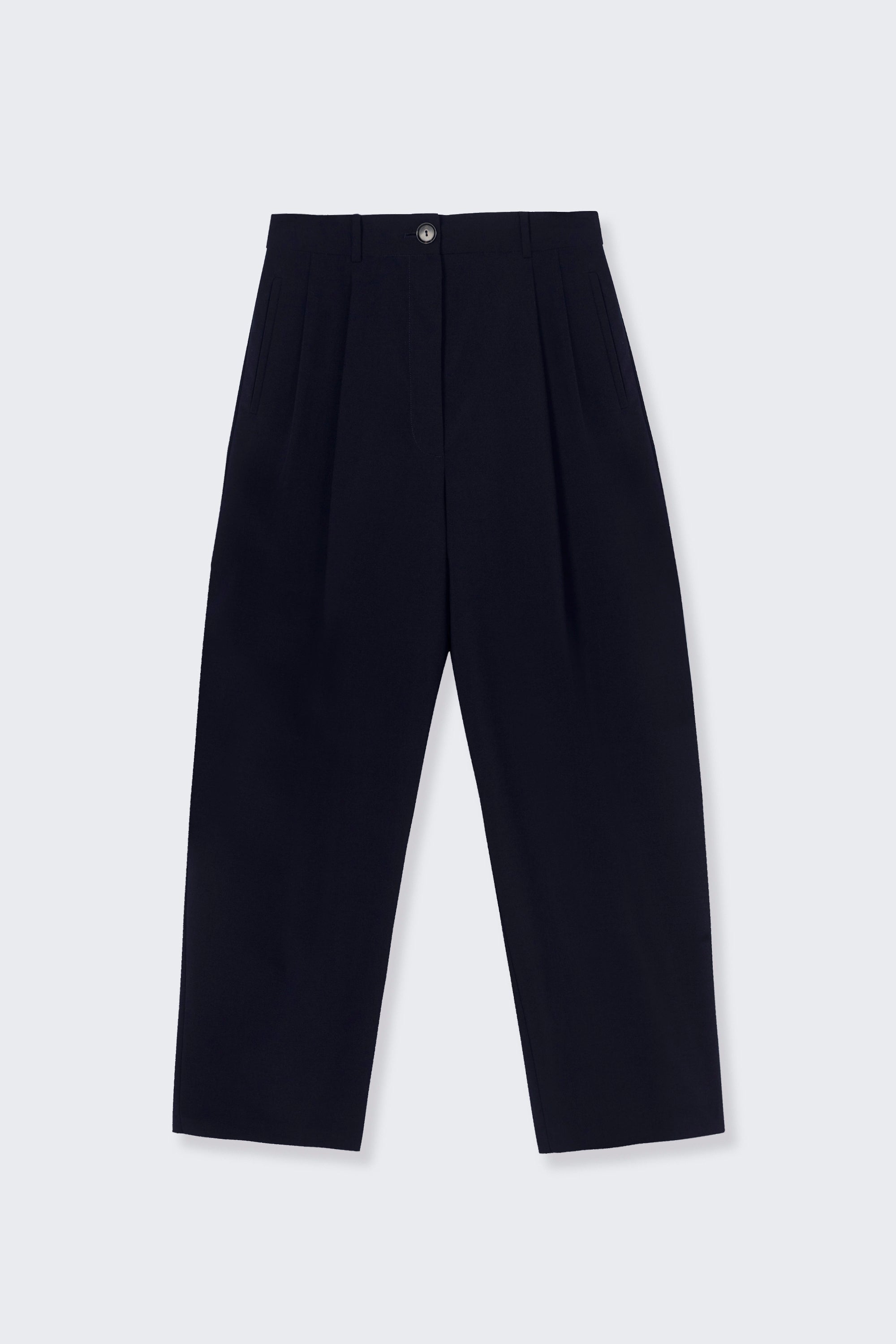 Product view of the Cordera Navy Blue Tailored Masculine Pants featuring a loose, masculine fit with a mid-rise and double front pleats for added structure. Details include jetted side pockets, back welt pockets, an elasticated waistband at the back, zip and button closure, and belt loops at Alas Eius. Made in Spain. 