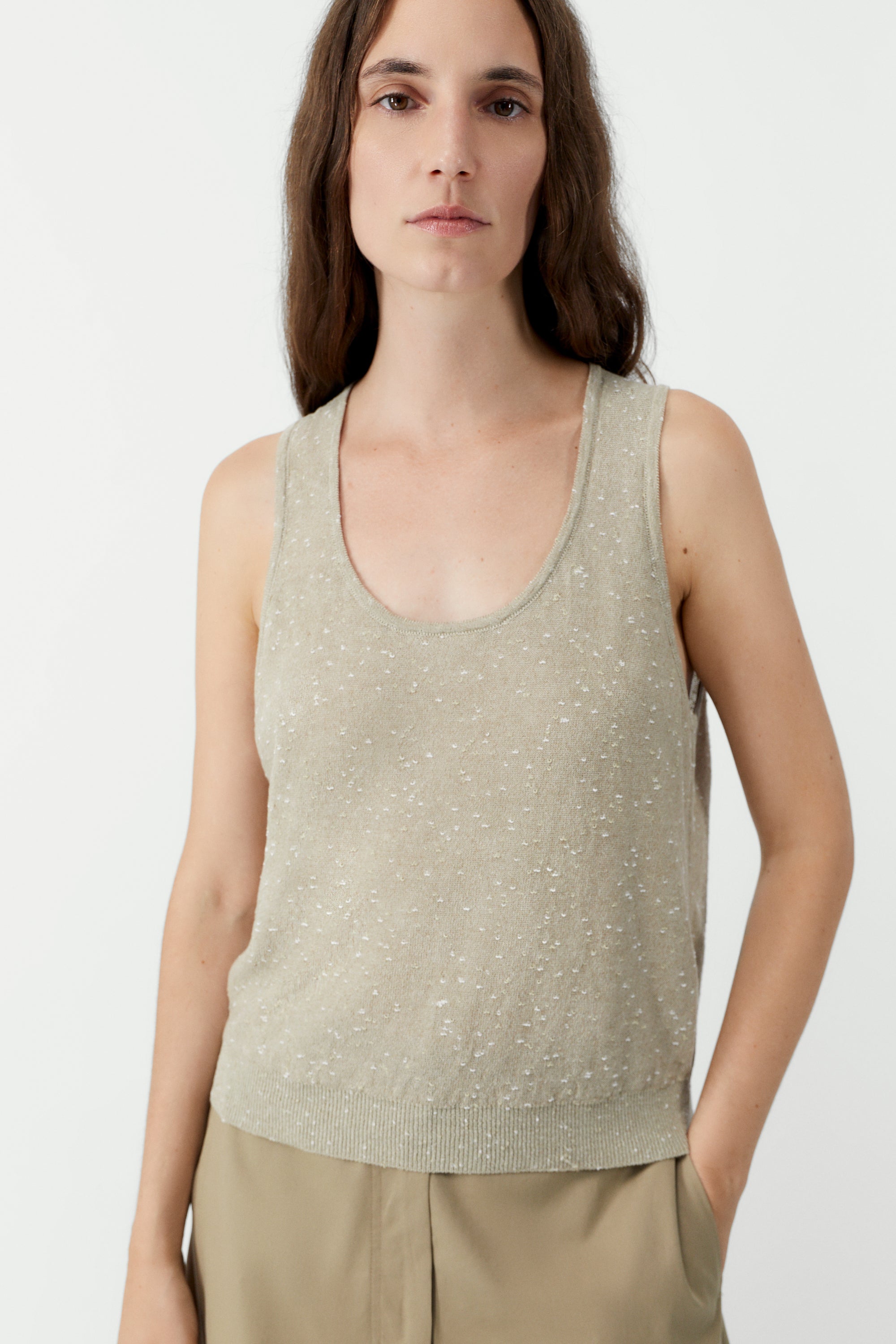 Front view of a woman standing wearing a versatile spring layering essential in the Cordera beige linen and cotton blend flecked tank top at Alas Eius.

This cardigan is ethically and carefully manufactured in La Coruña, with Japanese knitting machines and finished by hand. Made in Spain.