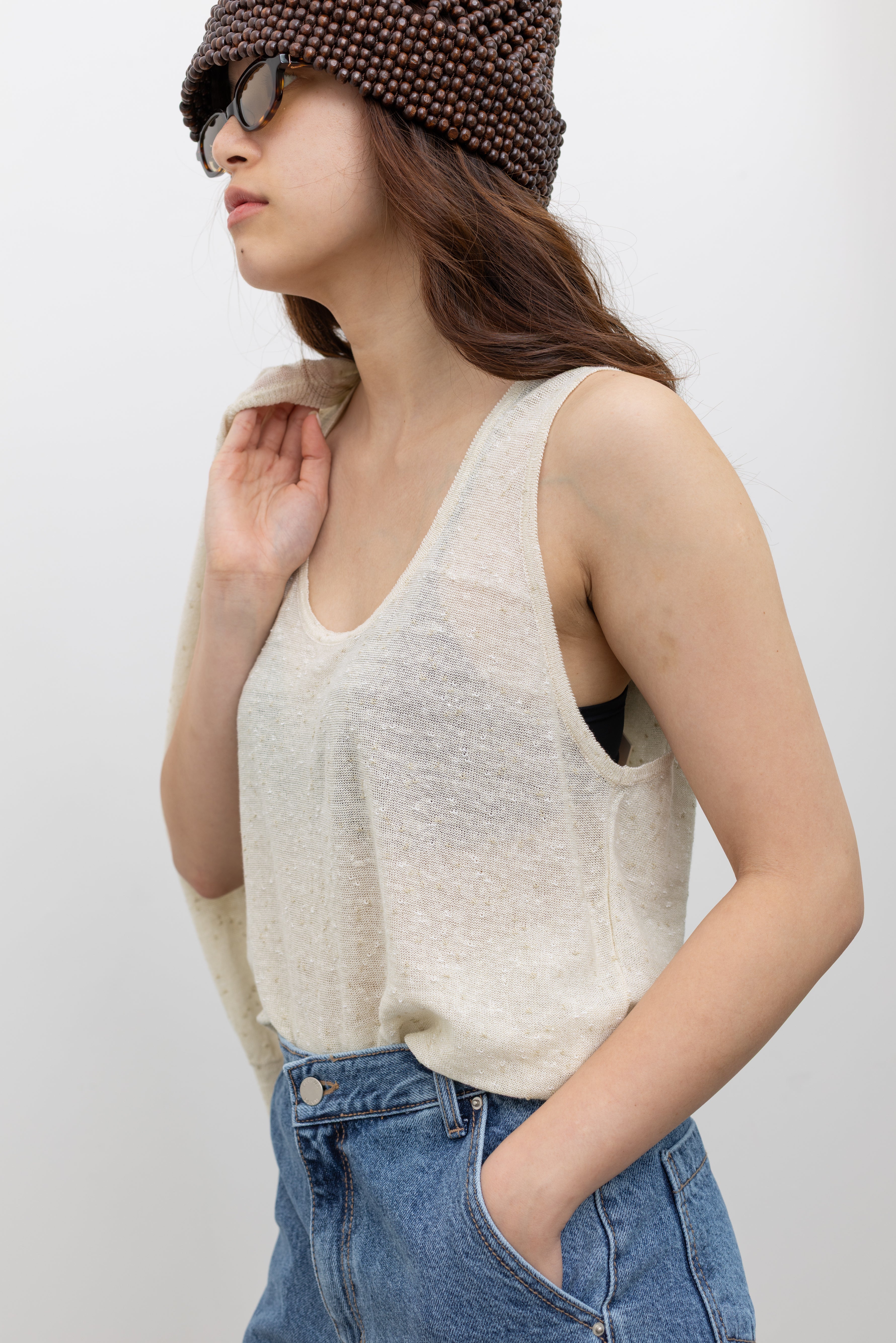 Model wearing chic women's summer top in a Cordera relaxed fit cream tank top with subtle flecked texture and breathable linen-cotton construction at Alas Eius. 