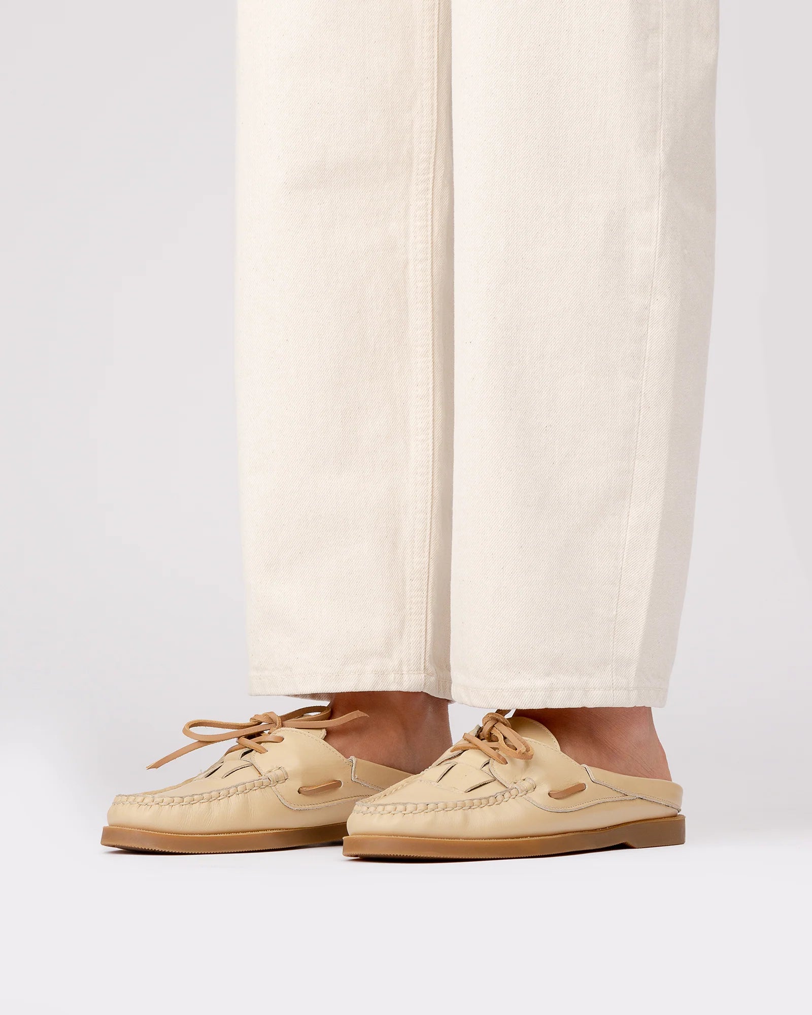 Woman wearing elevated spring footwear in the Hereu Beige Saler Nautic Muled Loafers featuring a classic boat shoe shape with leather ties at Alas Eius.
