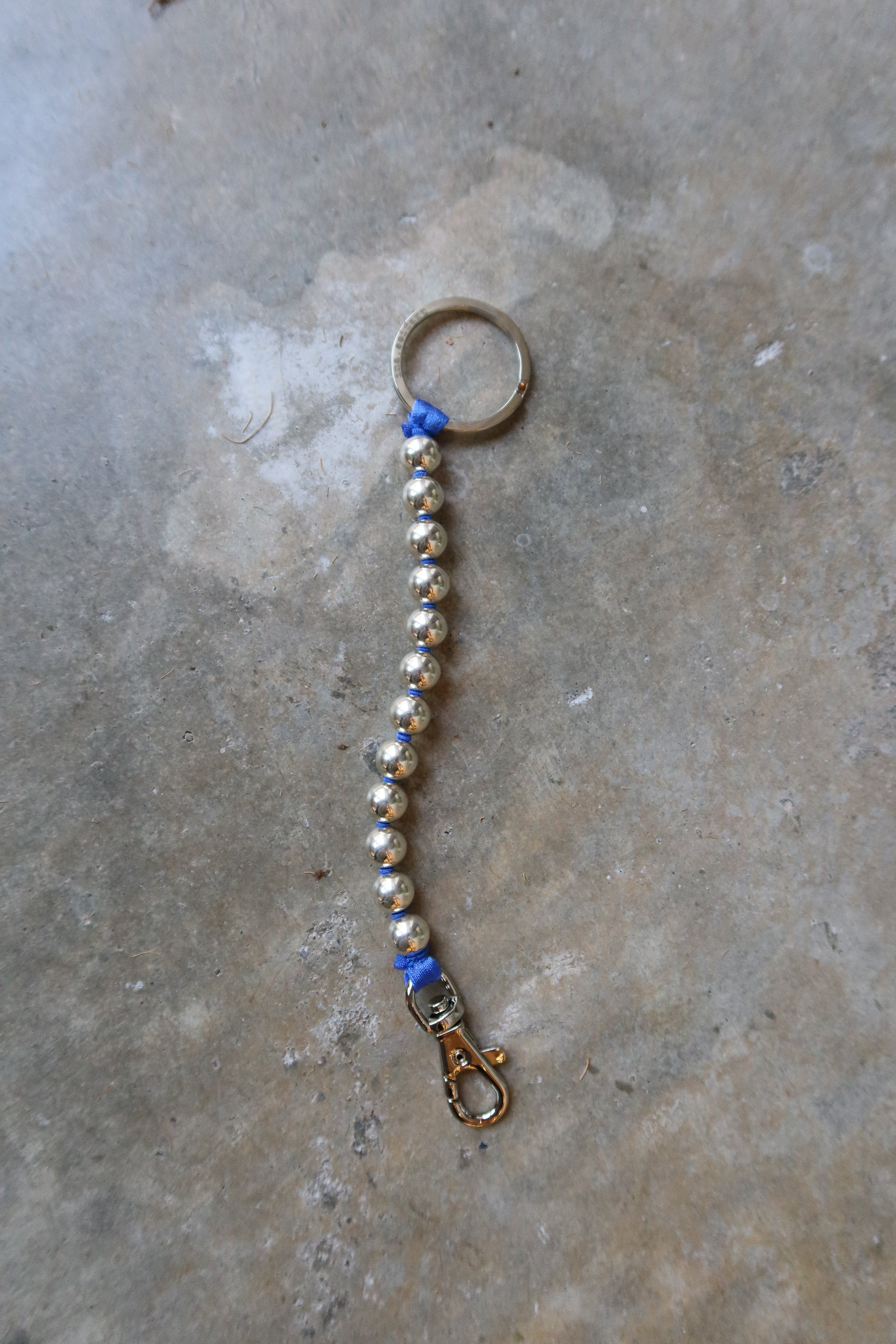 Ina Seifart Sterling Silver And Blue Ribbon Key or Phone Chain with elastic band and threaded 925 silver beads. Made with a cobalt blue ribbon thread and key ring and clasp on either end at Alas Eius