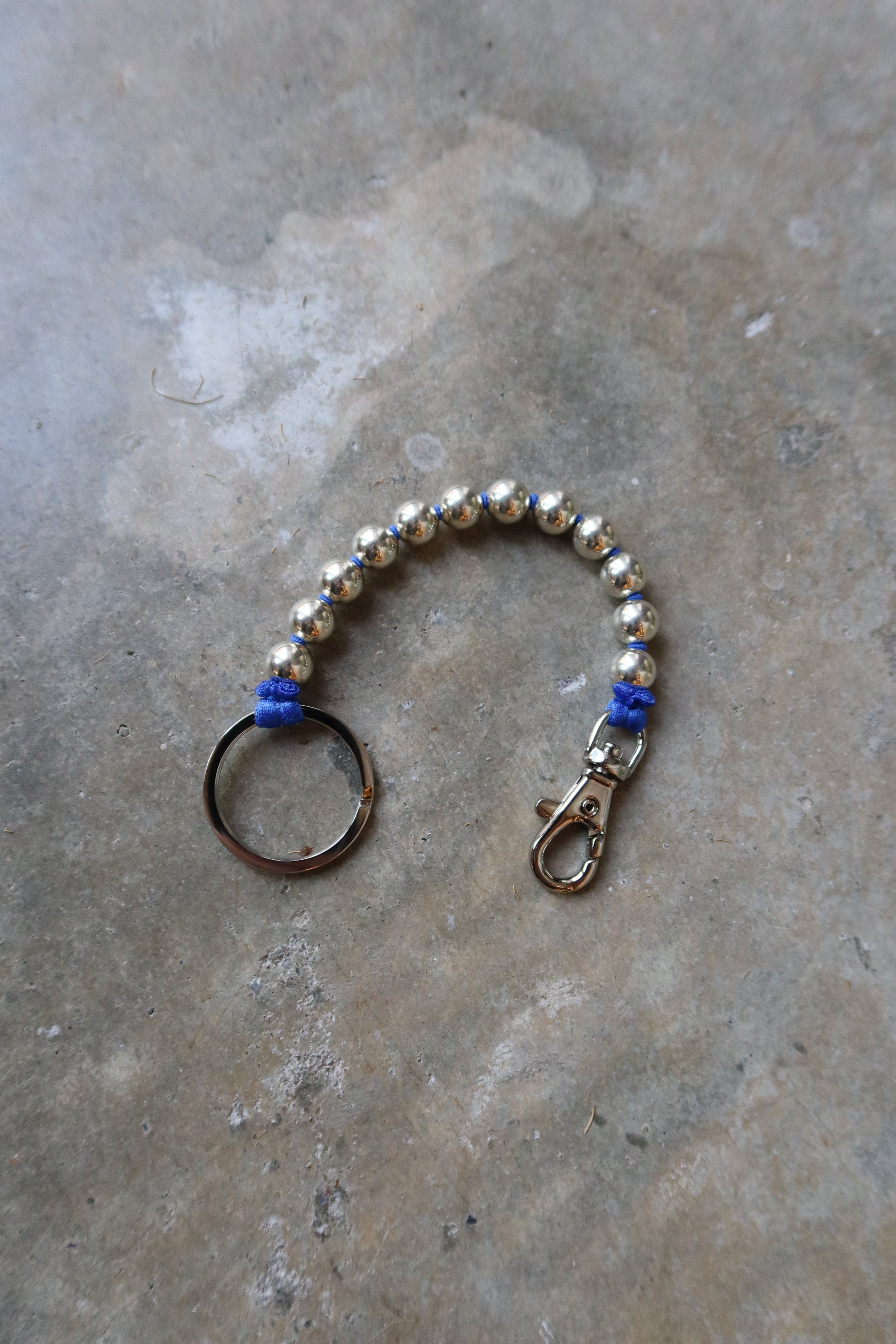 Ina Seifart Sterling Silver And Blue Ribbon Key or Phone Chain with elastic band and threaded 925 silver beads. Made with a cobalt blue ribbon thread and key ring and clasp on either end at Alas Eius