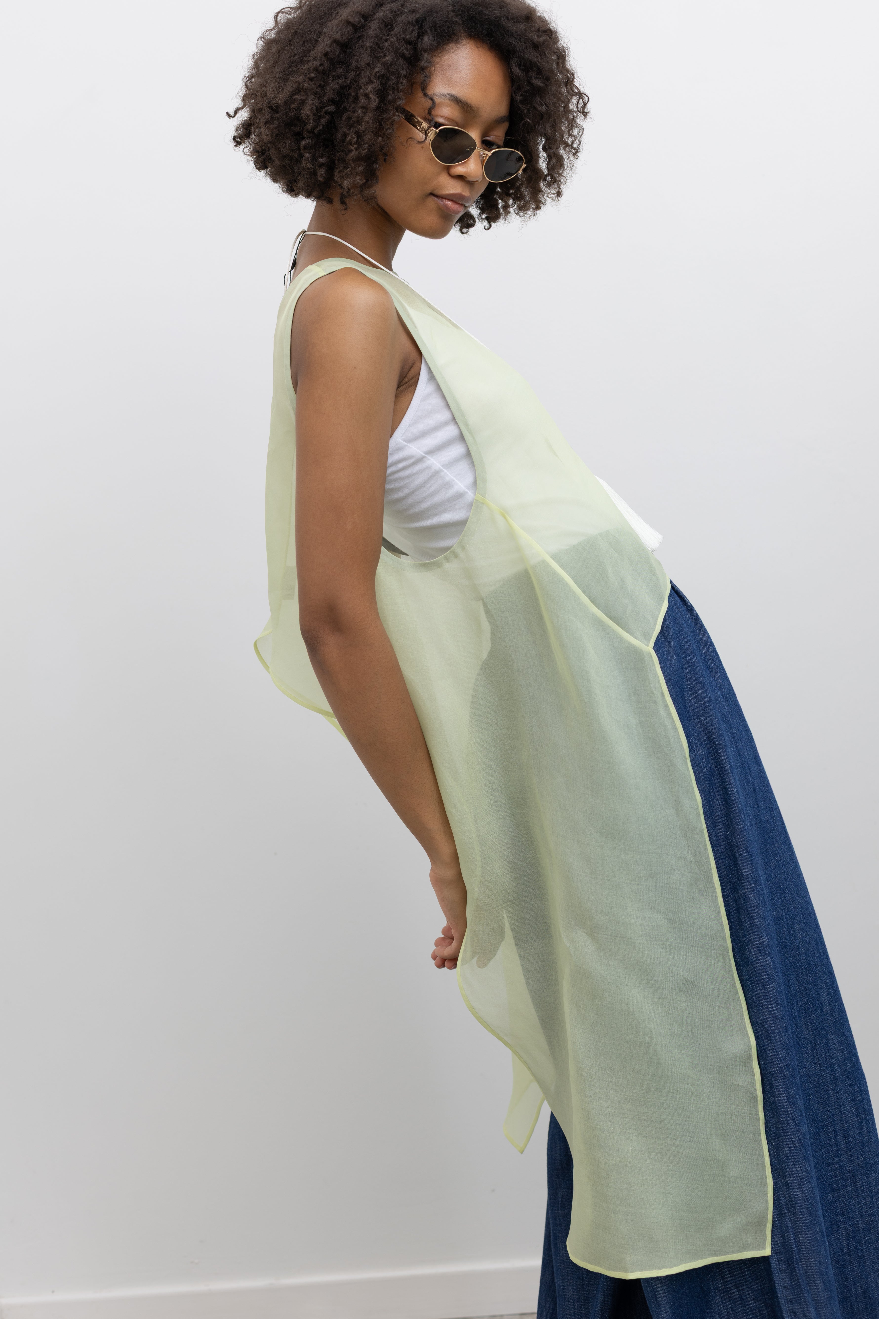 KAAREM Minimal sheer silk top with wide neckline and flowing side panels designed for layered styling at Alas Eius.