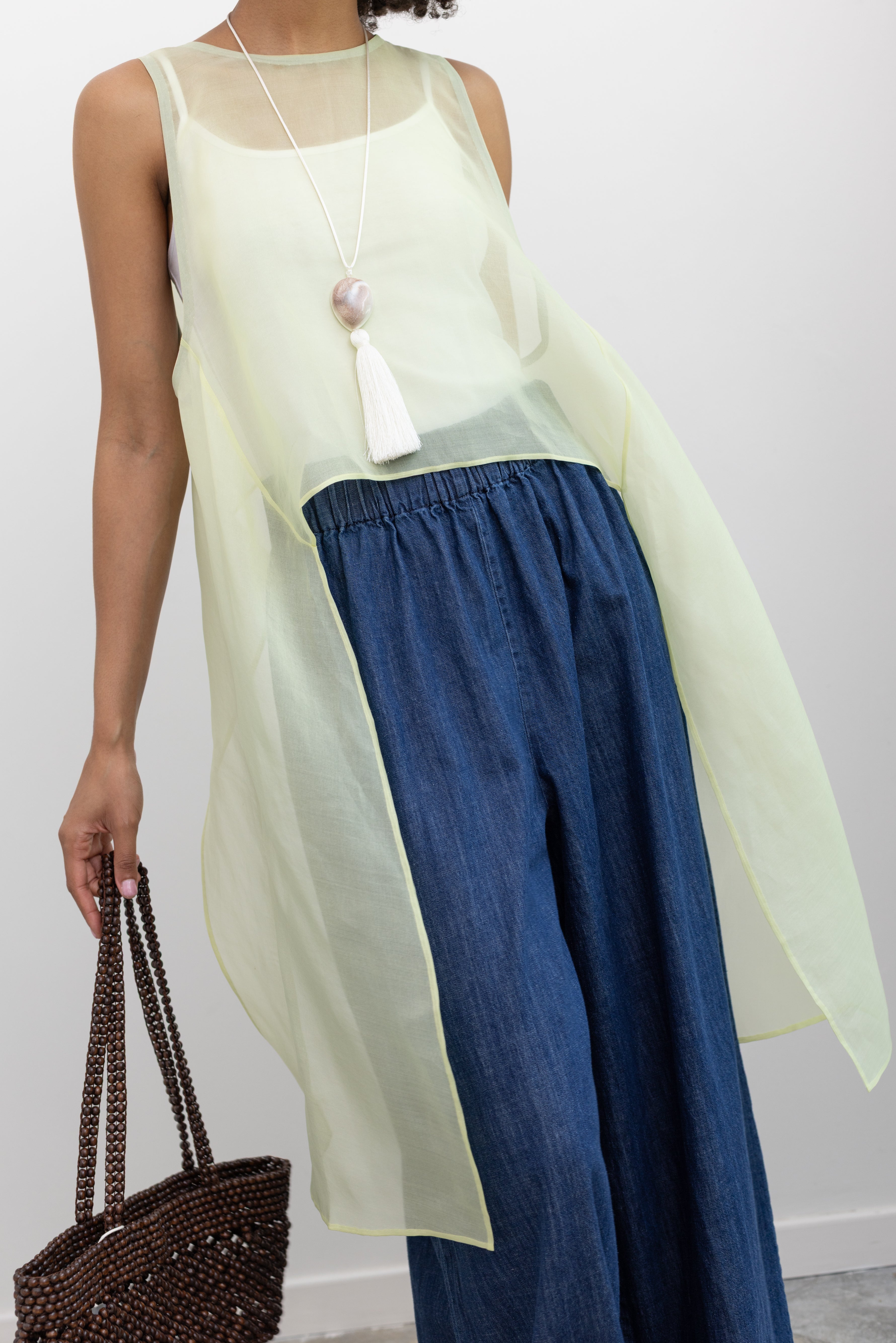 KAAREM Lightweight transparent layering top in silk organza featuring sculptural side extensions and a wide neckline at Alas Eius. 