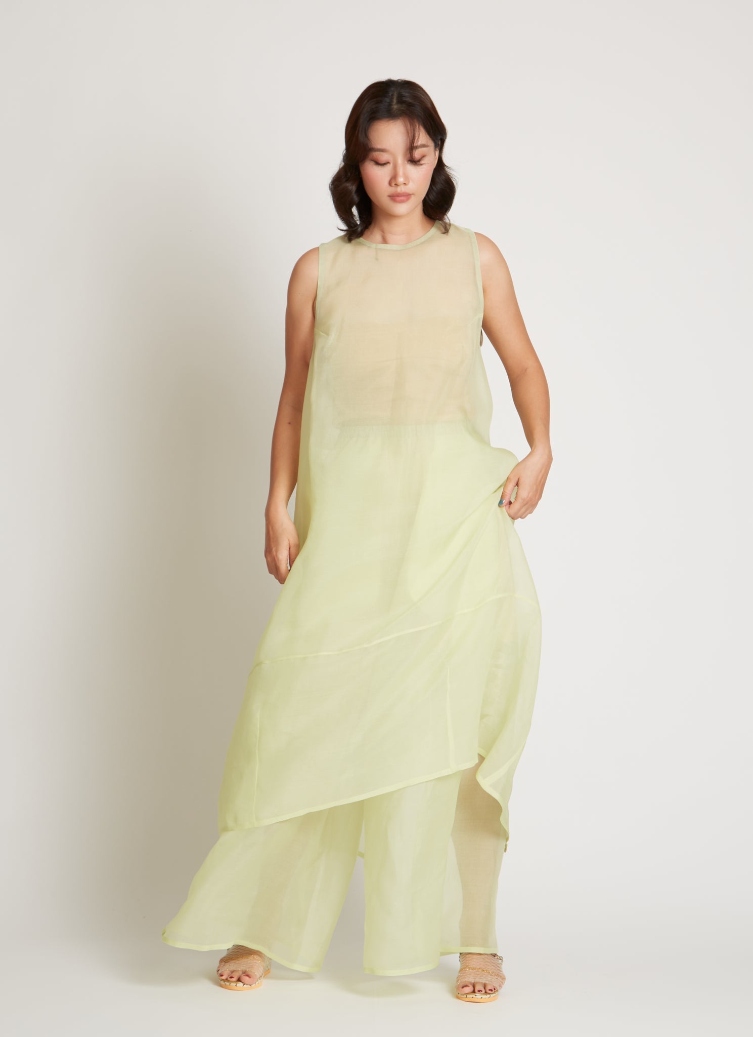Kaarem SS26 Sheer Green Rice Marble Pleated Silk Organza Pant featuring a wide-leg silhouette, deep side pleats, and finished by a single artisan with a hand-drawn pattern and a delicate blind-hem stitch, featuring an elastic waistband and side pockets for practical ease at Alas EIus.