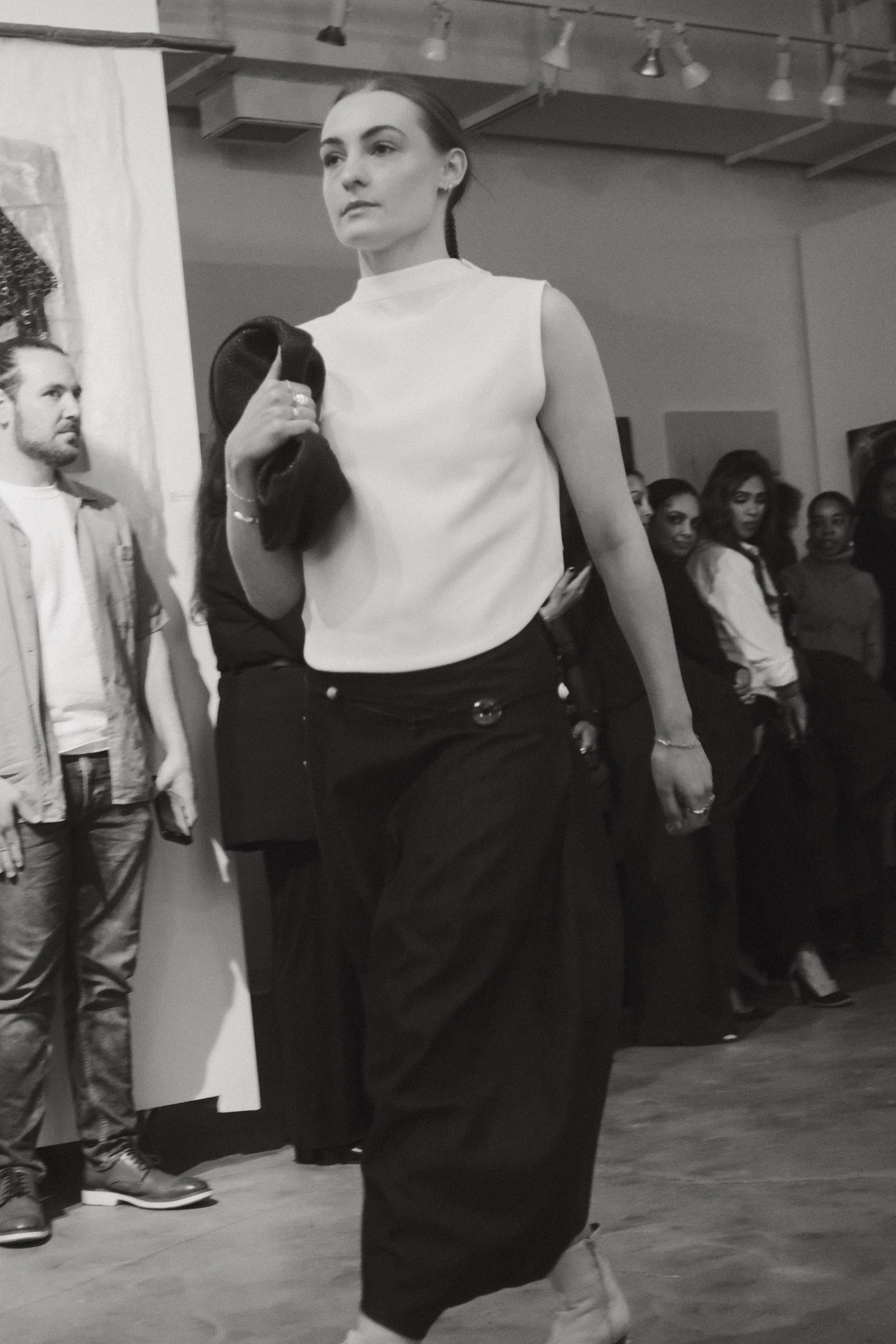 Front view of a woman wearing capsule wardrobe essential style in a Kaarem White Raised Collar Wind Chime Cropped Top at Alas Eius.