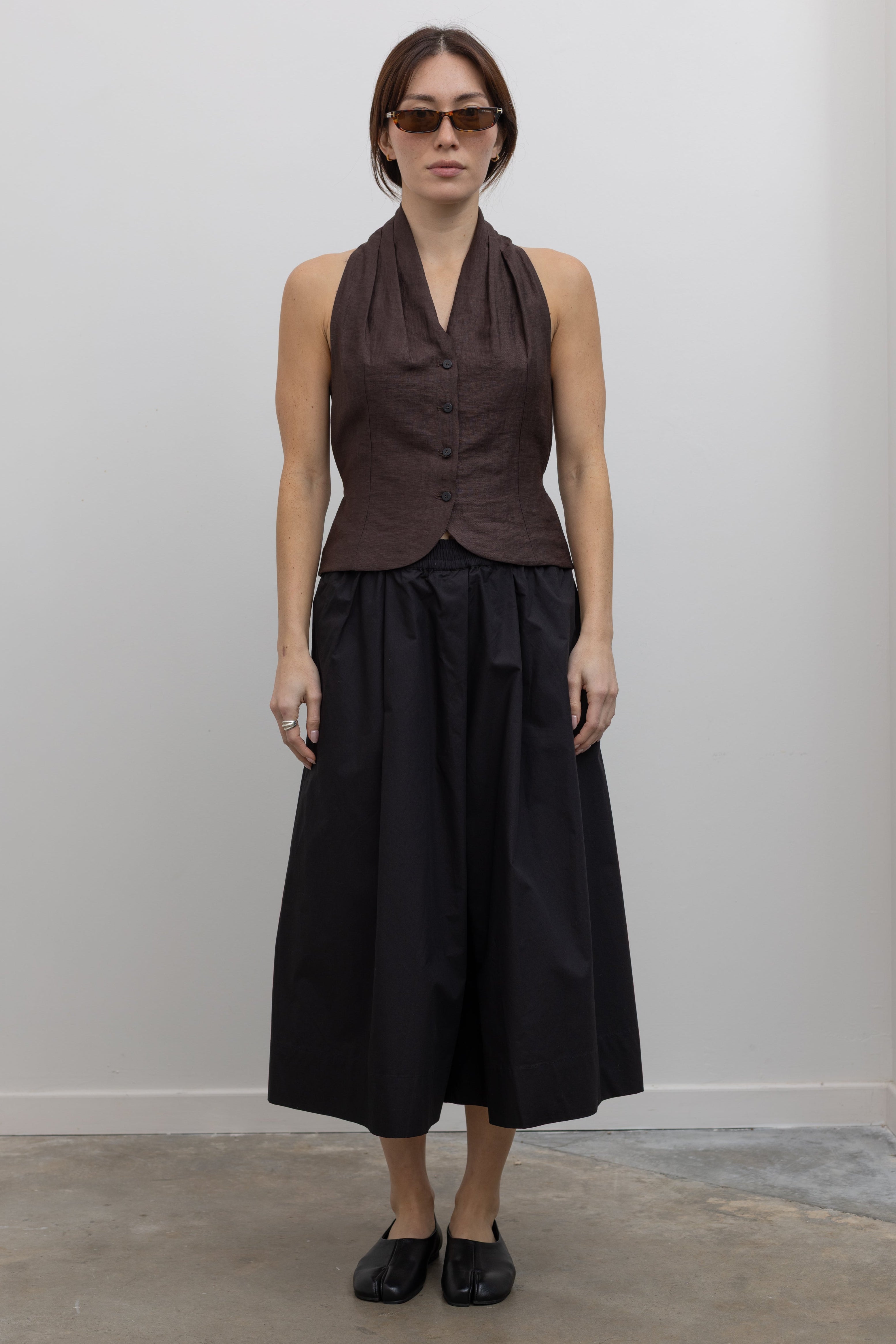 Woman wearing Spring fashion in a brown linen buttoned vest with flattering Kowtow Black Organic Cotton Elastic Waistband Culottes at Alas Eius