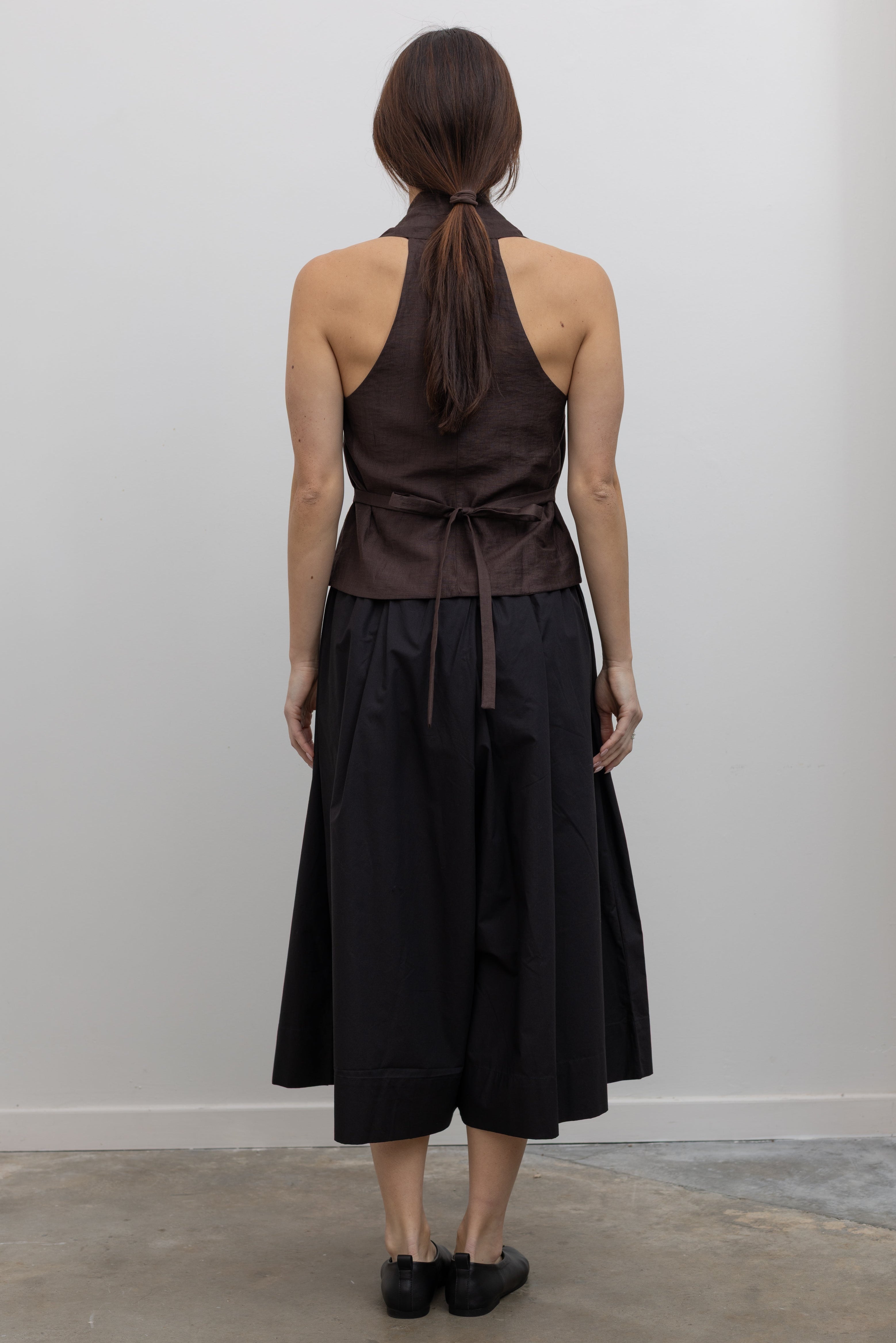 Back view of Woman wearing Spring fashion in a brown linen buttoned vest with flattering Kowtow Black Organic Cotton Elastic Waistband Culottes at Alas Eius