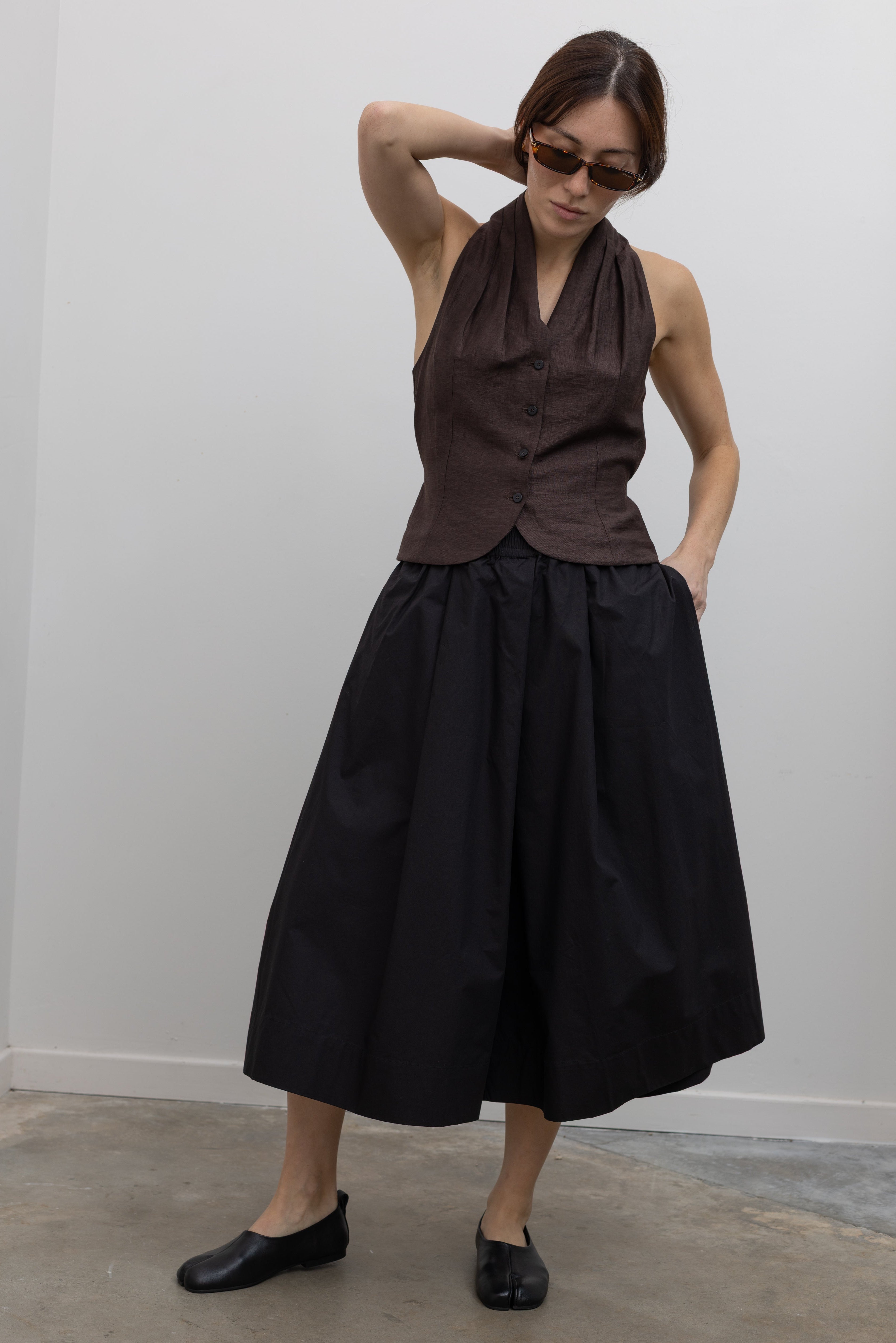 Woman wearing Spring fashion in a brown linen buttoned vest with flattering Kowtow Black Organic Cotton Elastic Waistband Culottes at Alas Eius
