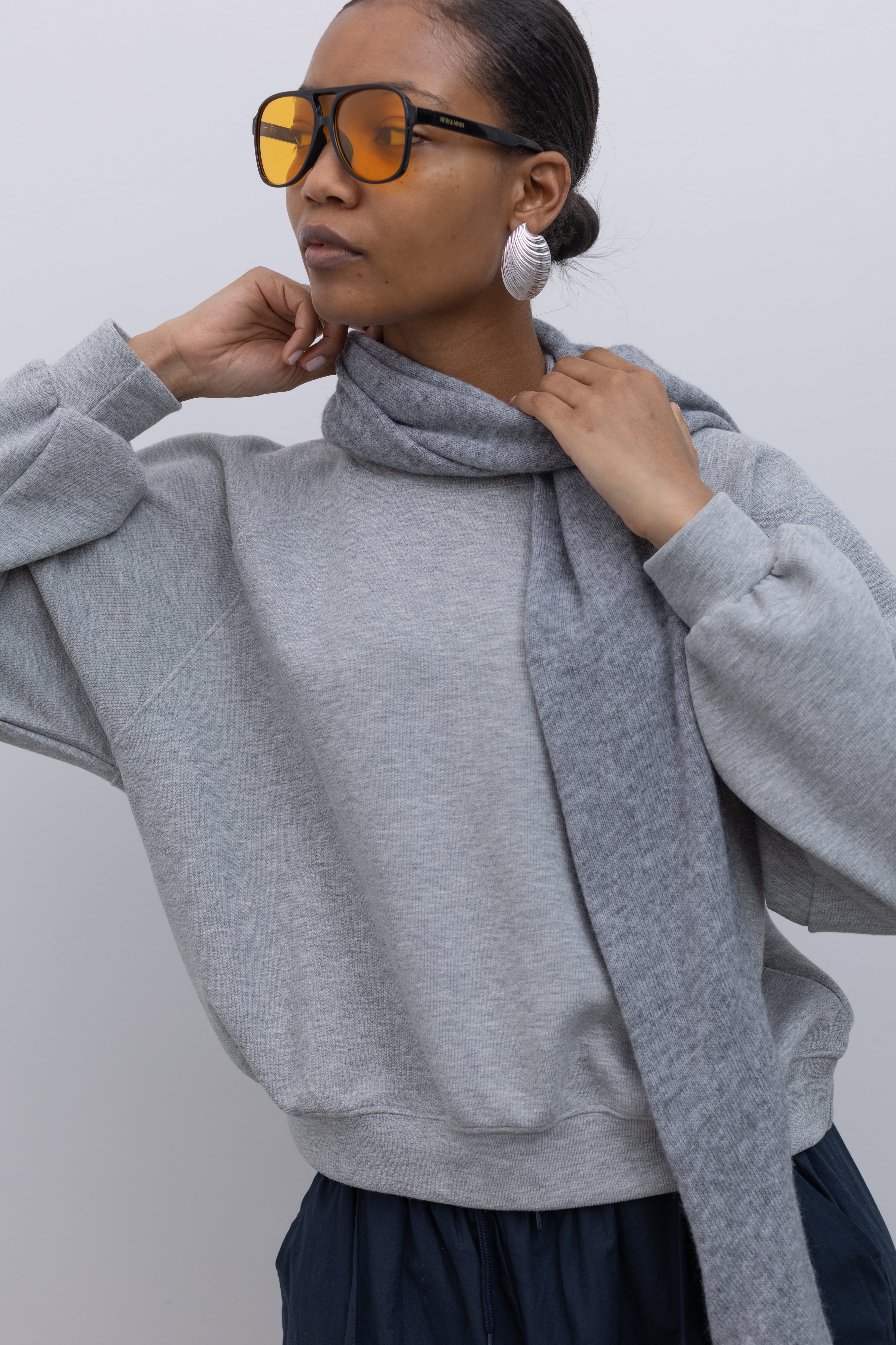 Close-up view of a woman wearing winter fashion accessory in a Le Bon Shoppe Gray Cashmere Wool blend bandana Shawl at Alas Eius 
