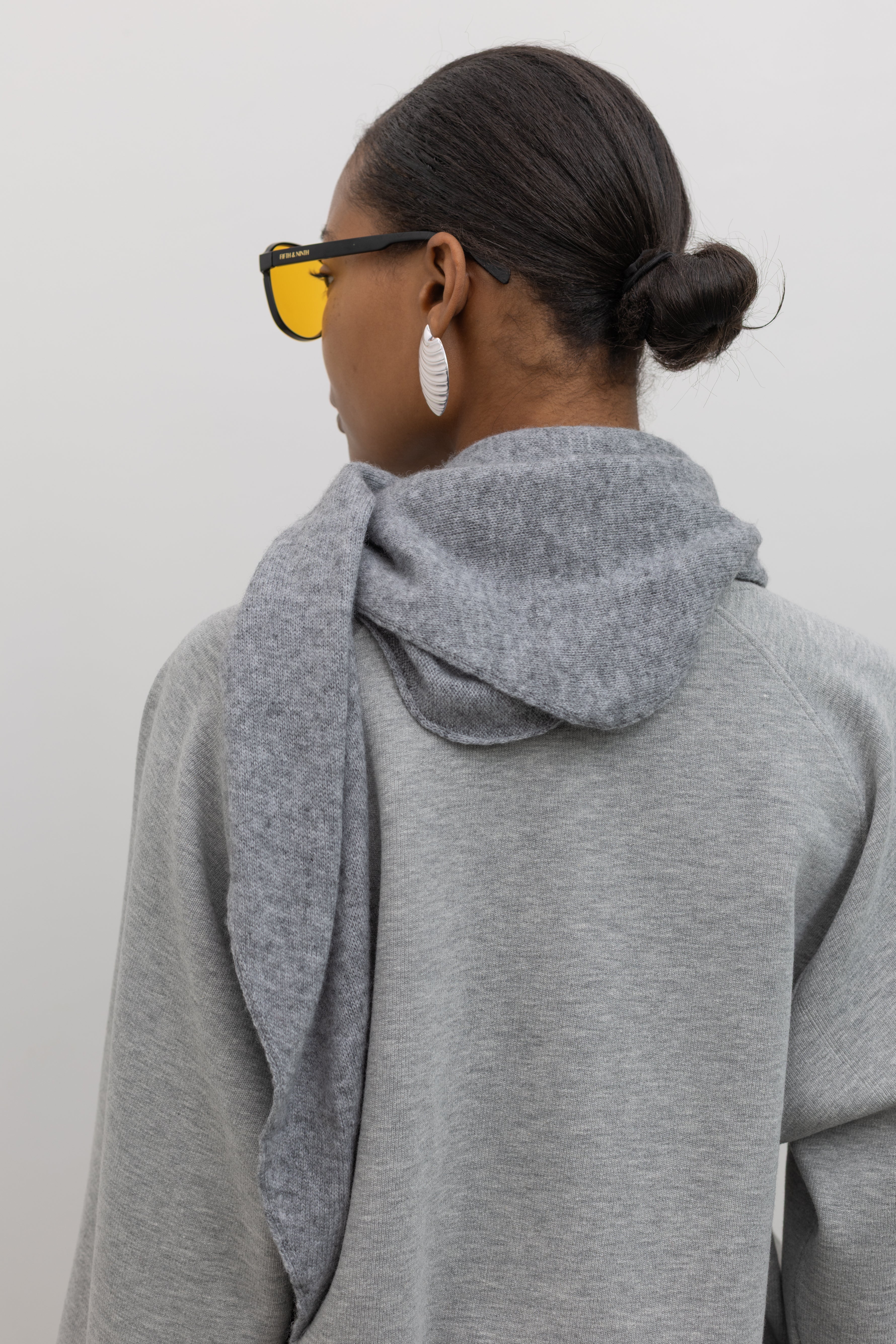 Back view of a woman wearing winter accessory in a Le Bon Shoppe Gray Cashmere Wool blend bandana Shawl at Alas Eius 